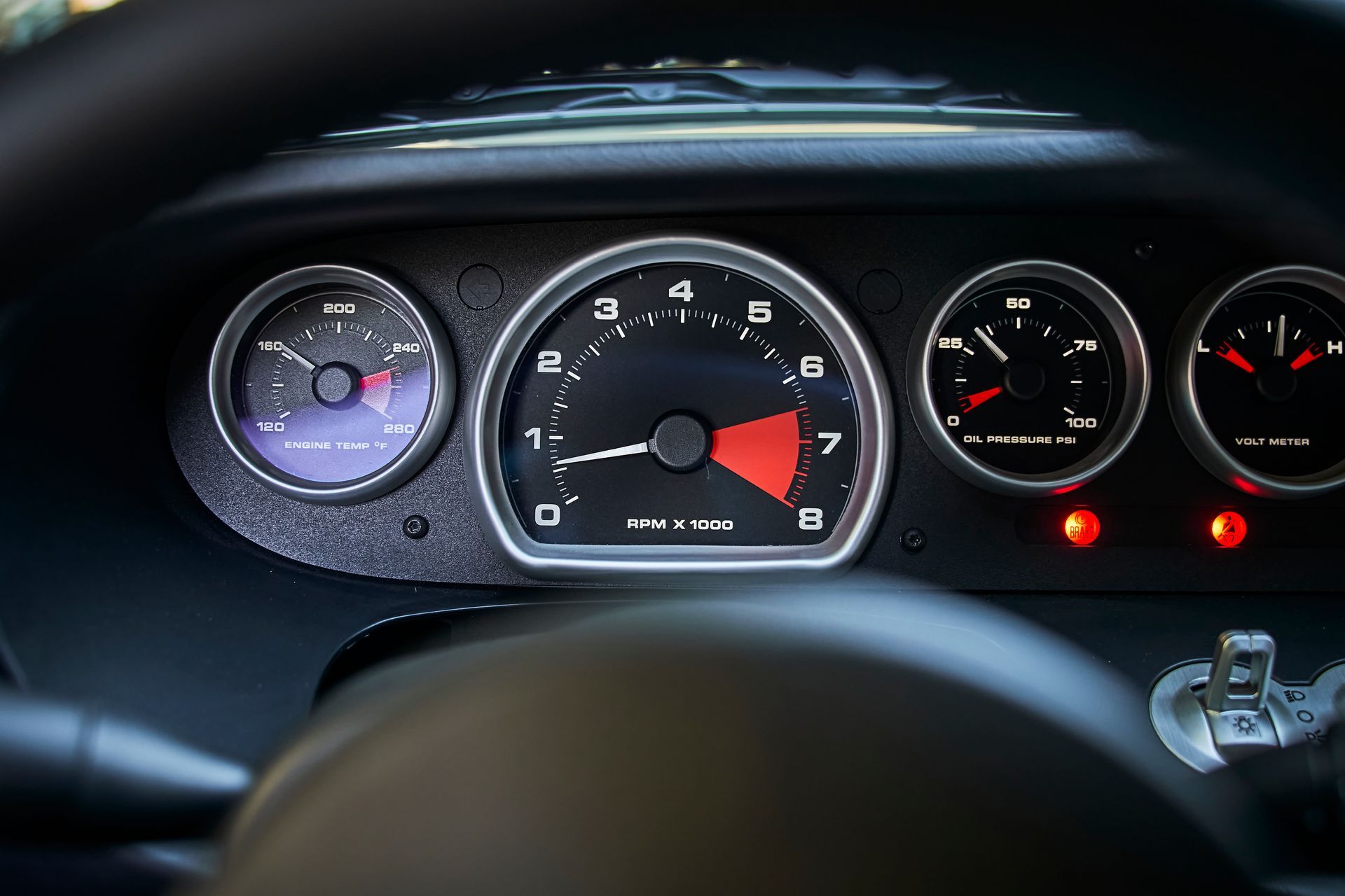 A close up of a car dashboard with a tachometer and other gauges