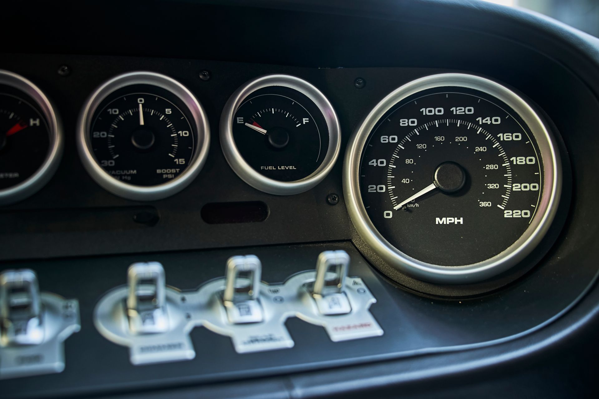 A close up of a car dashboard with a speedometer and a tachometer