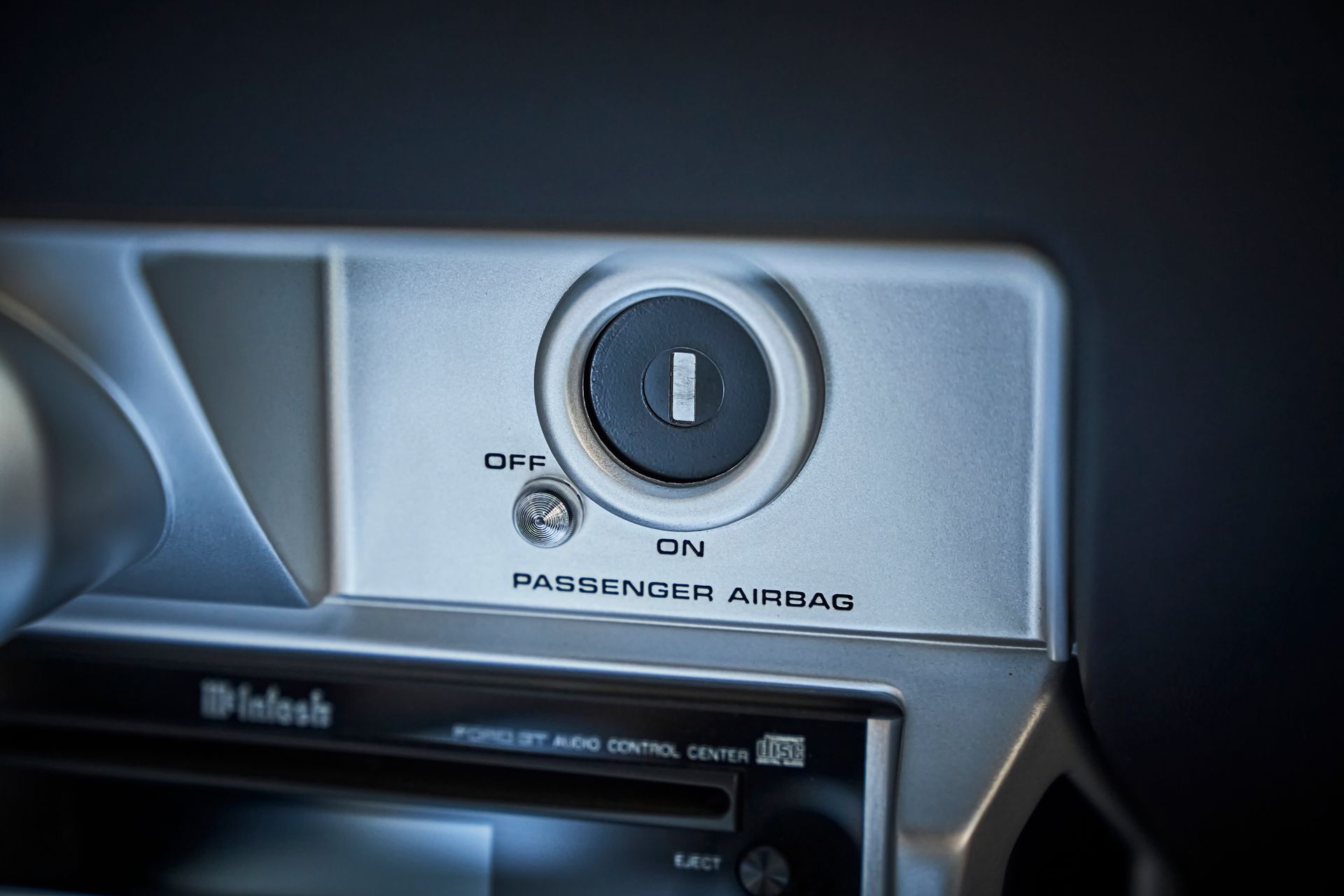 A close up of a passenger air bag switch on a car radio