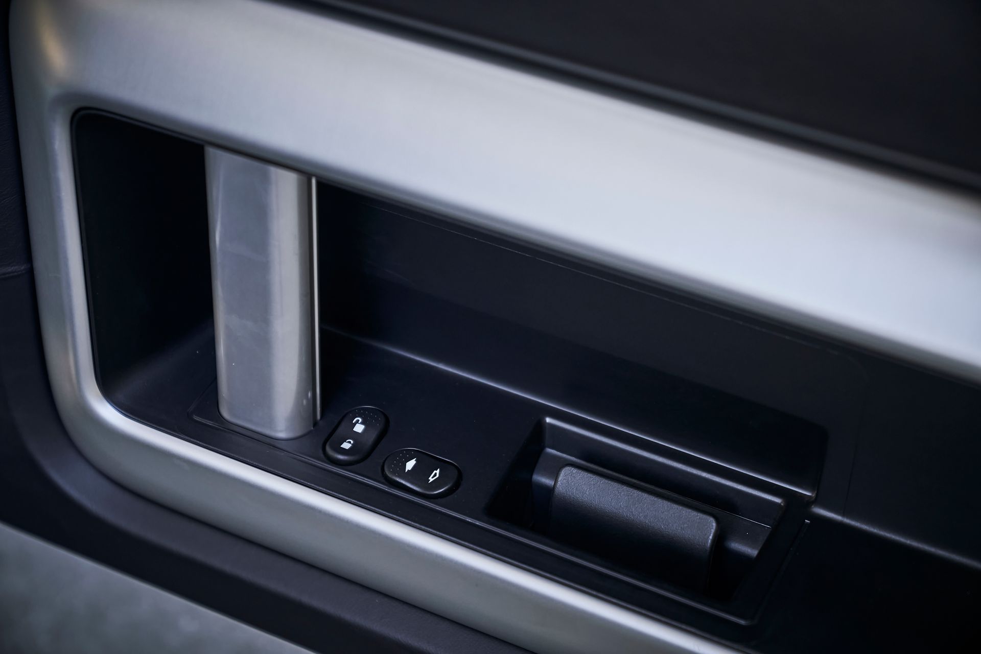 A close up of a car door with a remote control.