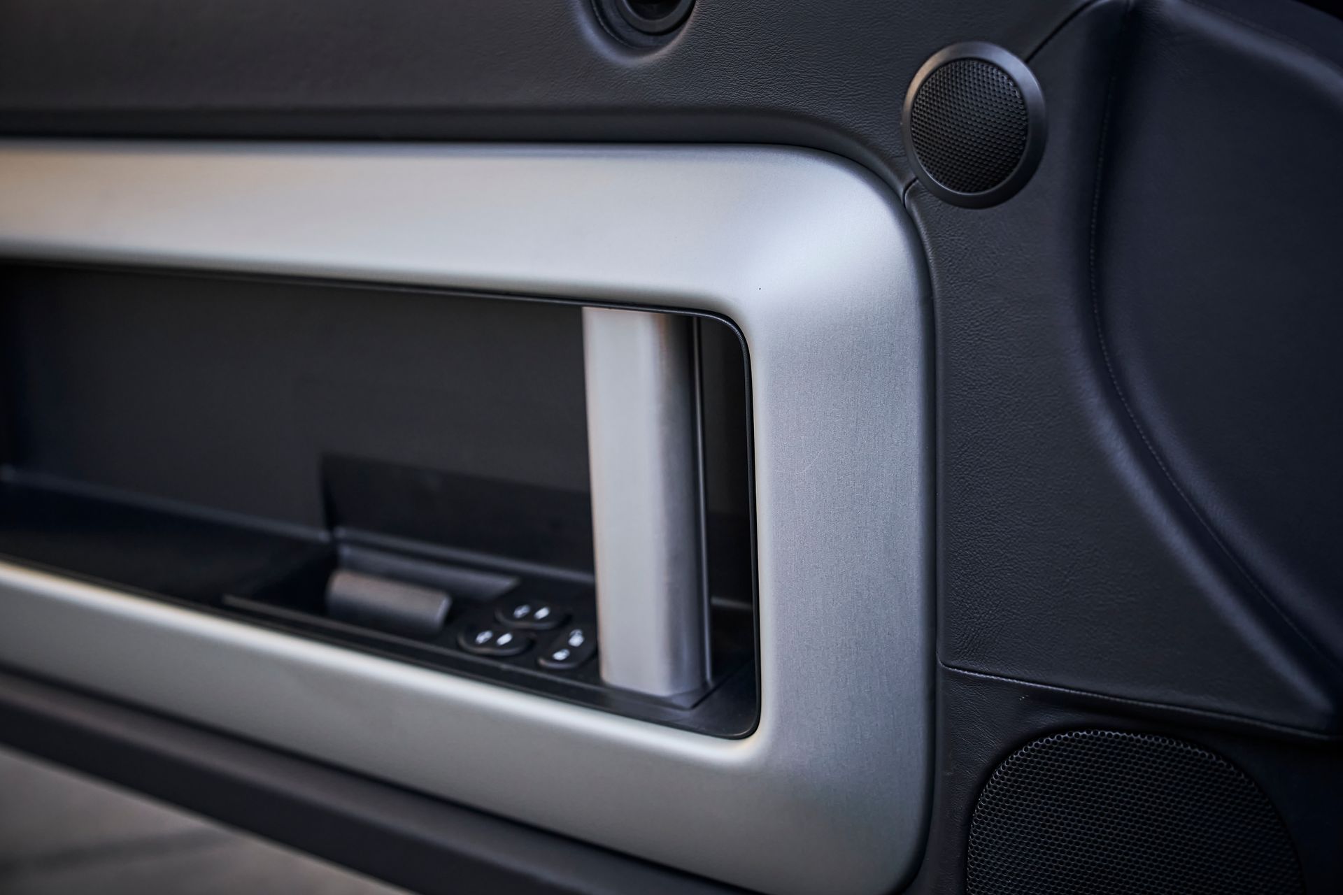 A close up of a car door handle on a black car.