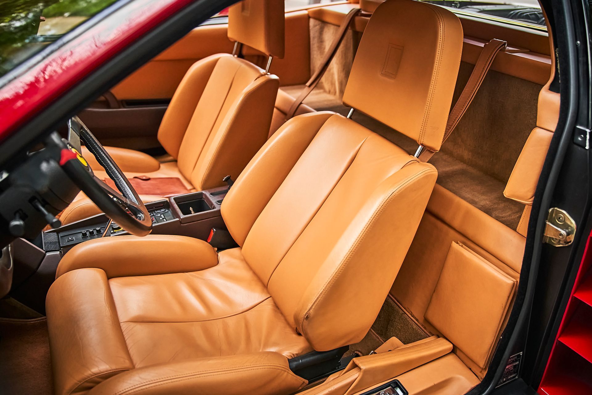 The interior of a car with brown leather seats and a steering wheel.