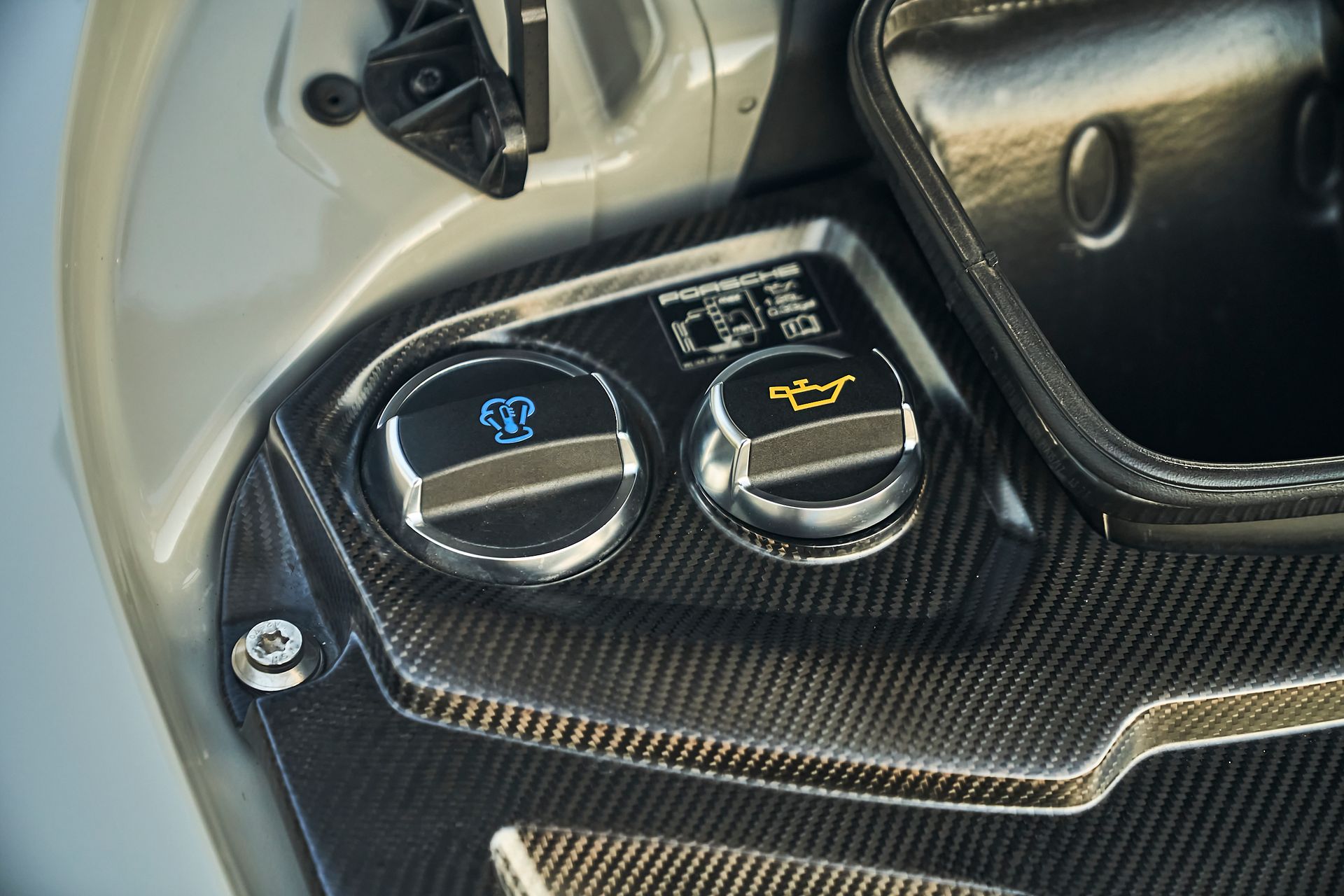 A close up of a car engine with two oil caps on it.
