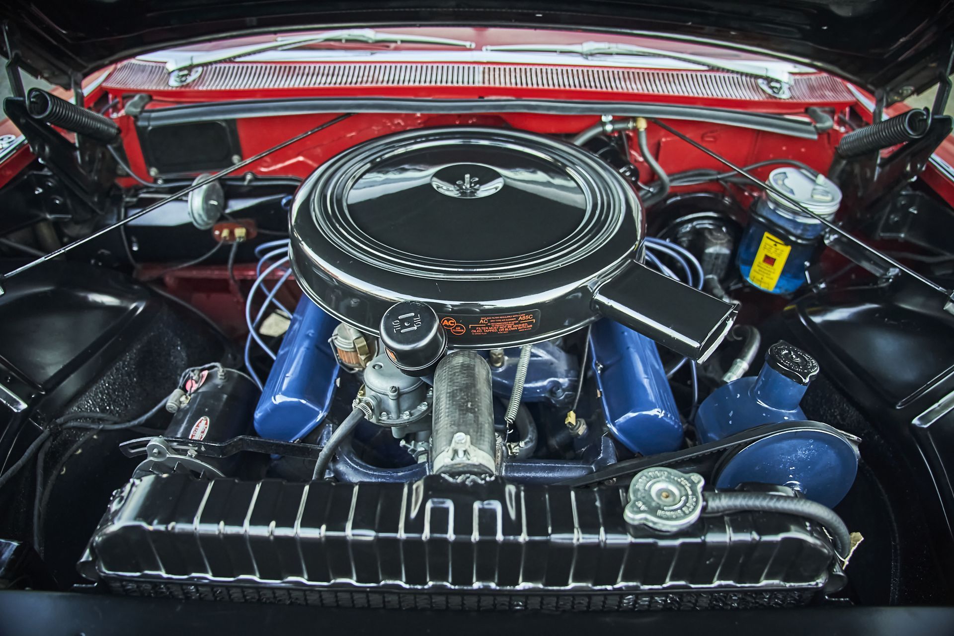 A close up of a car engine with the hood open