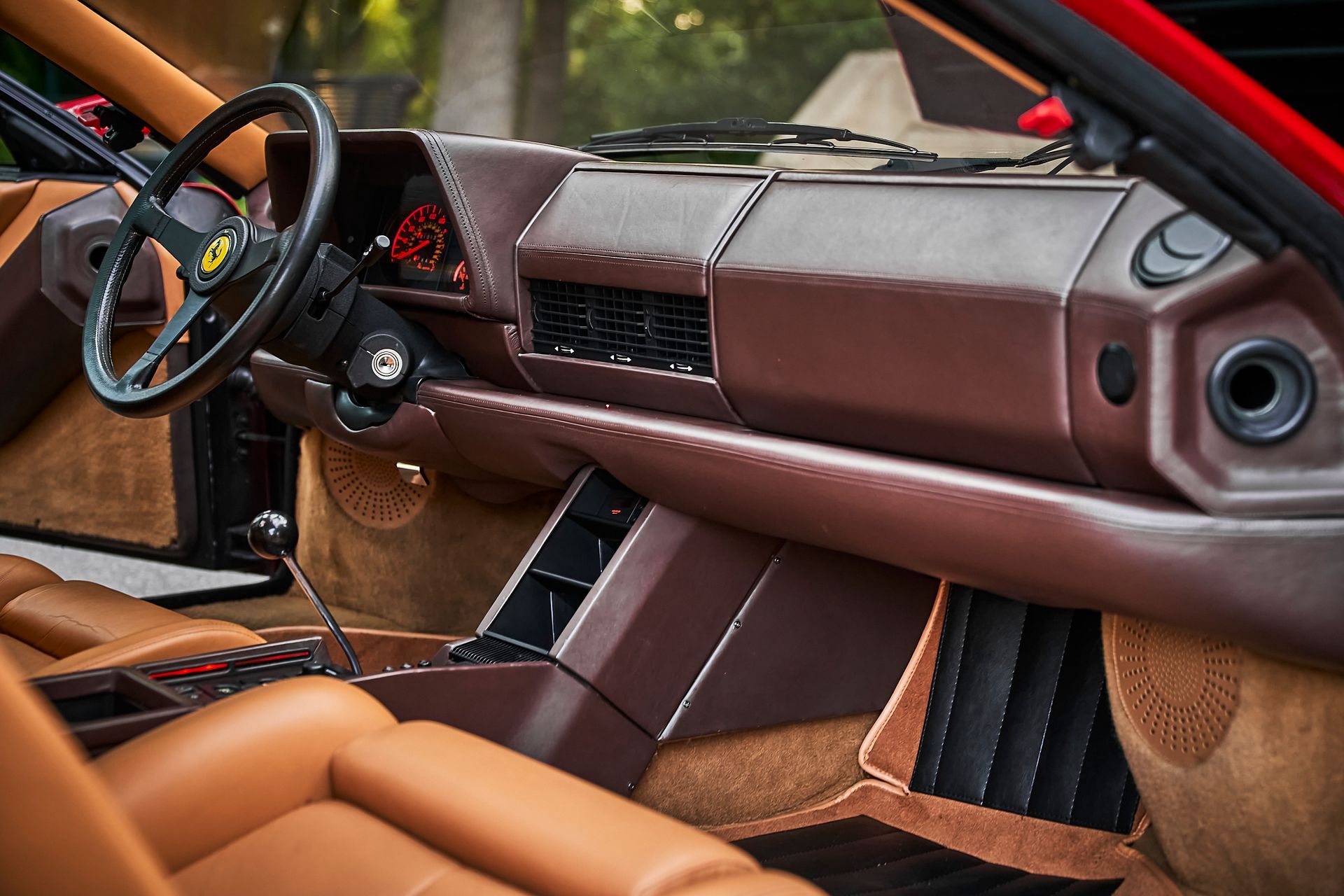The interior of a car with brown leather seats and a steering wheel.