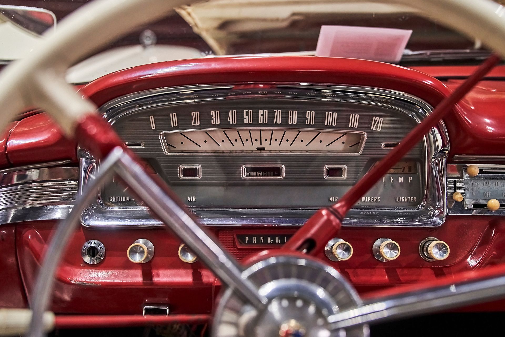A close up of the dashboard of an old red car