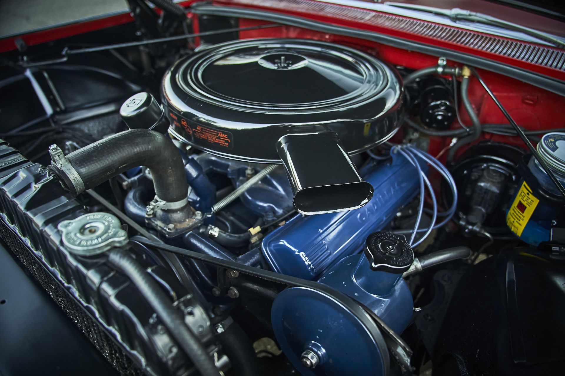 A close up of a car engine with a black air filter.