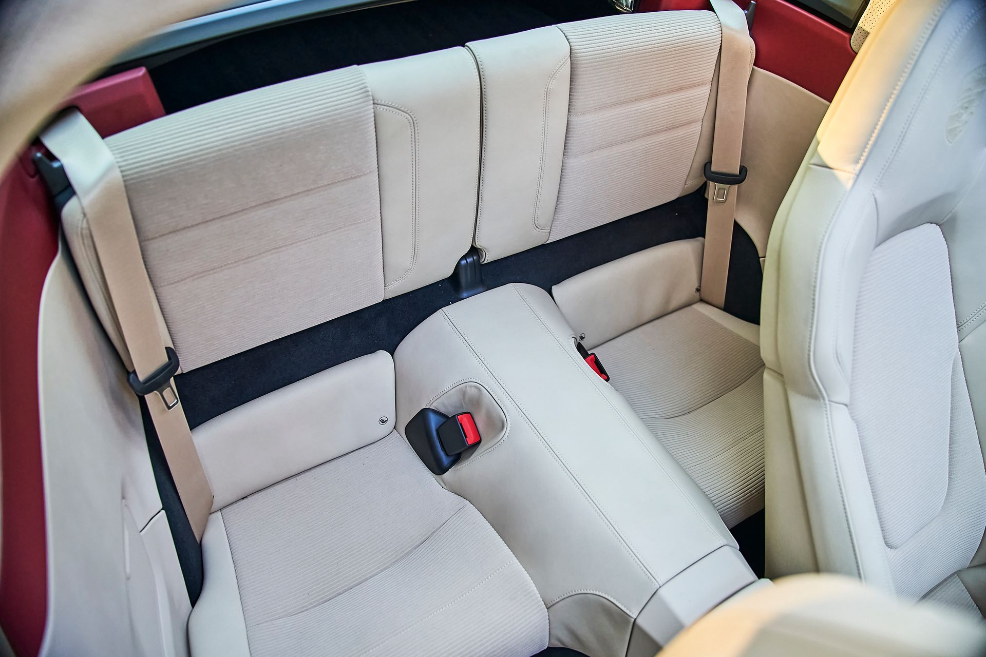 The back seat of a car with seat belts on it