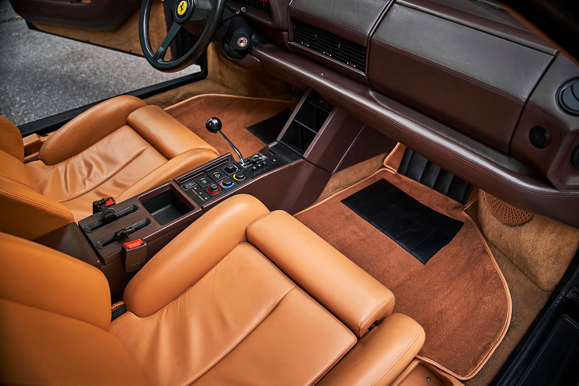 The interior of a car with brown leather seats and a steering wheel.
