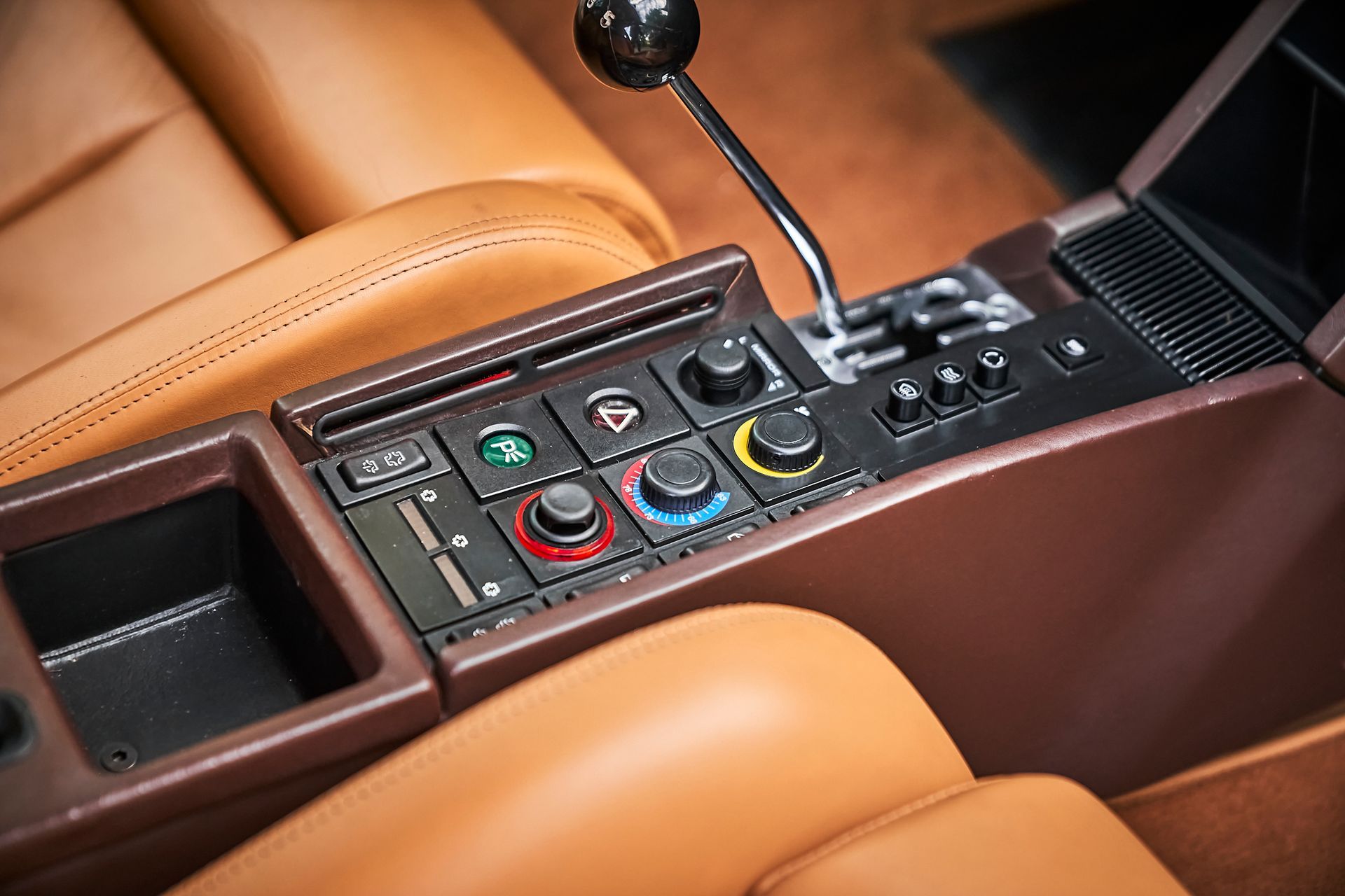 A close up of a steering wheel and controls in a car.