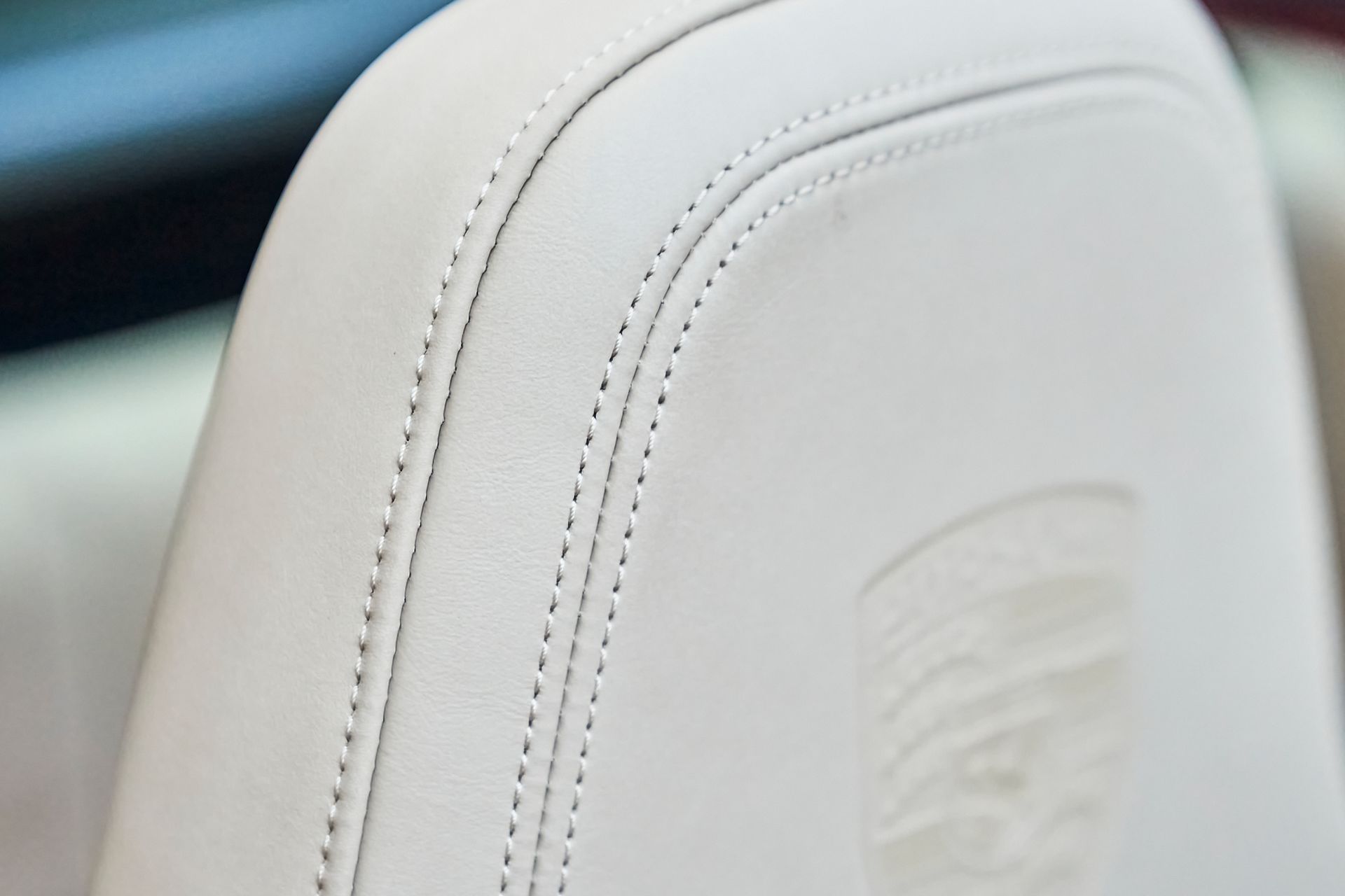 A close up of a white leather seat in a car.