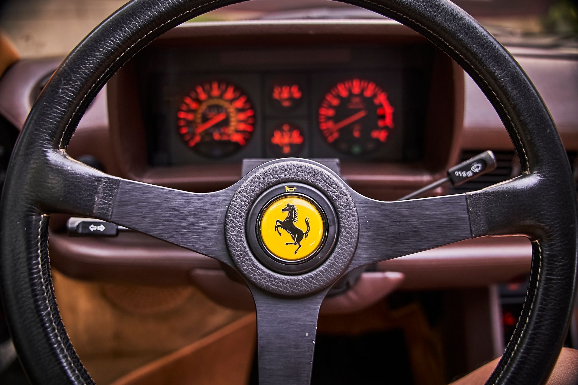 A close up of a ferrari steering wheel and dashboard