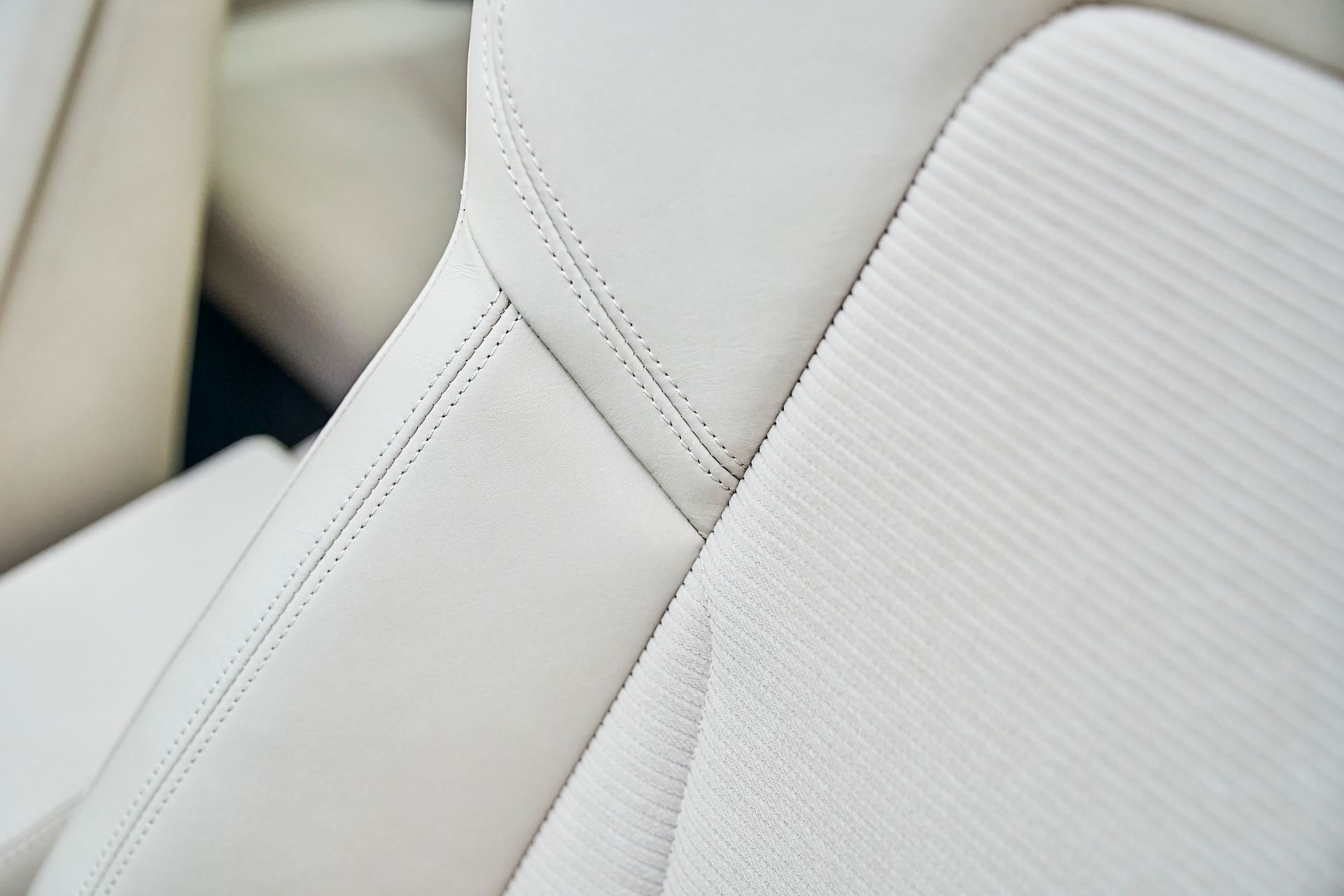 A close up of a white leather seat in a car.