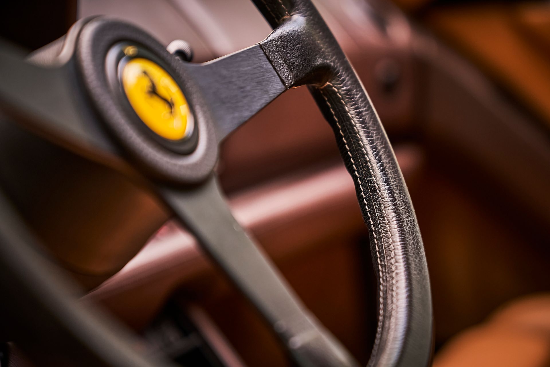 A close up of a steering wheel with a ferrari logo on it.