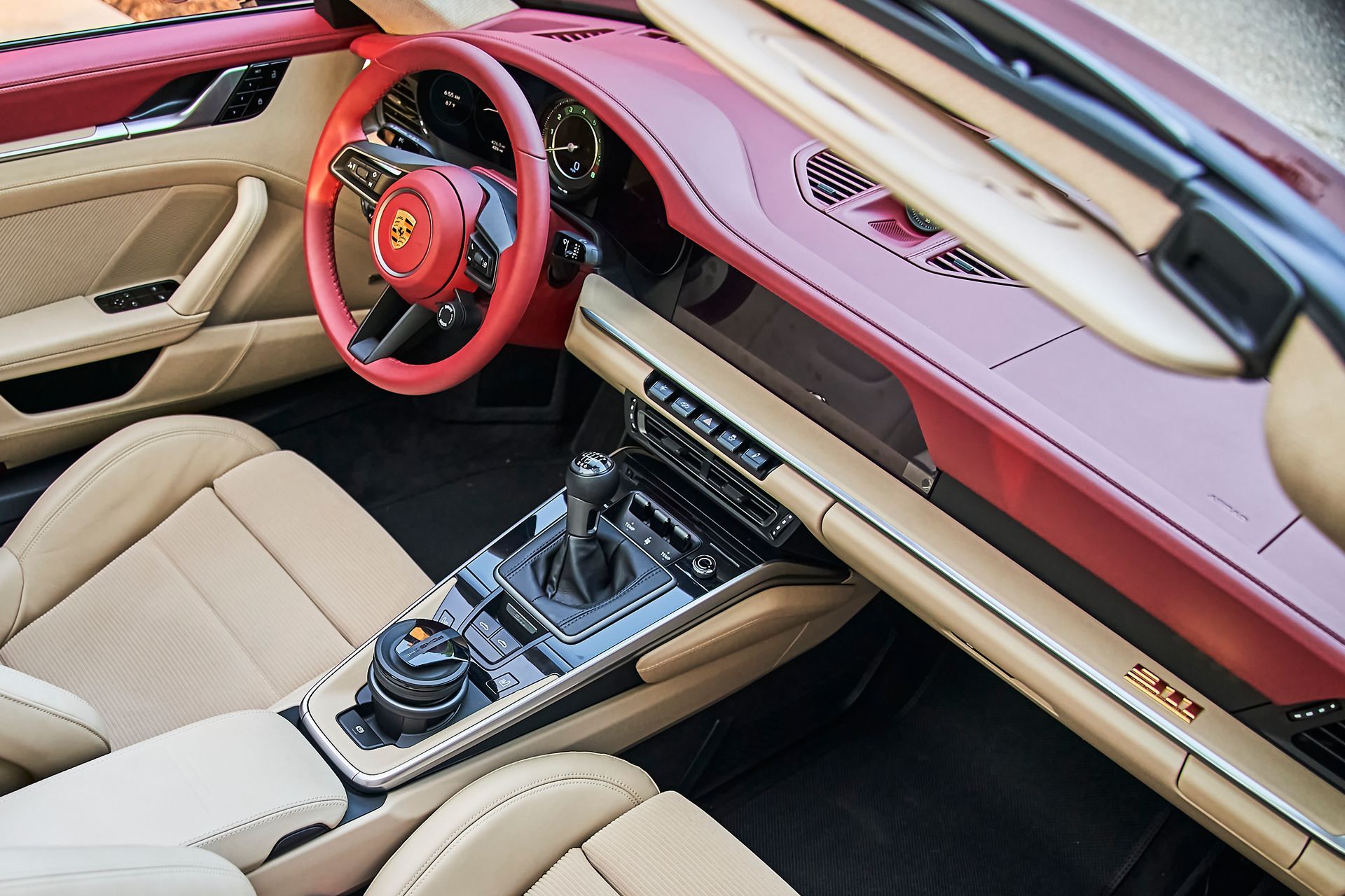 The interior of a porsche 911 convertible with a red steering wheel