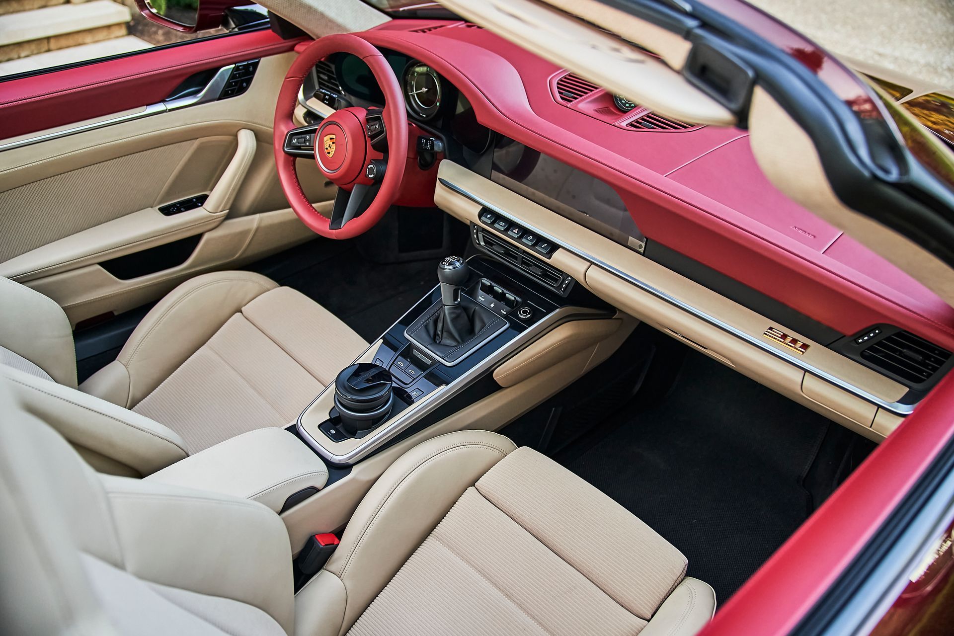 The interior of a porsche 911 convertible with a red steering wheel