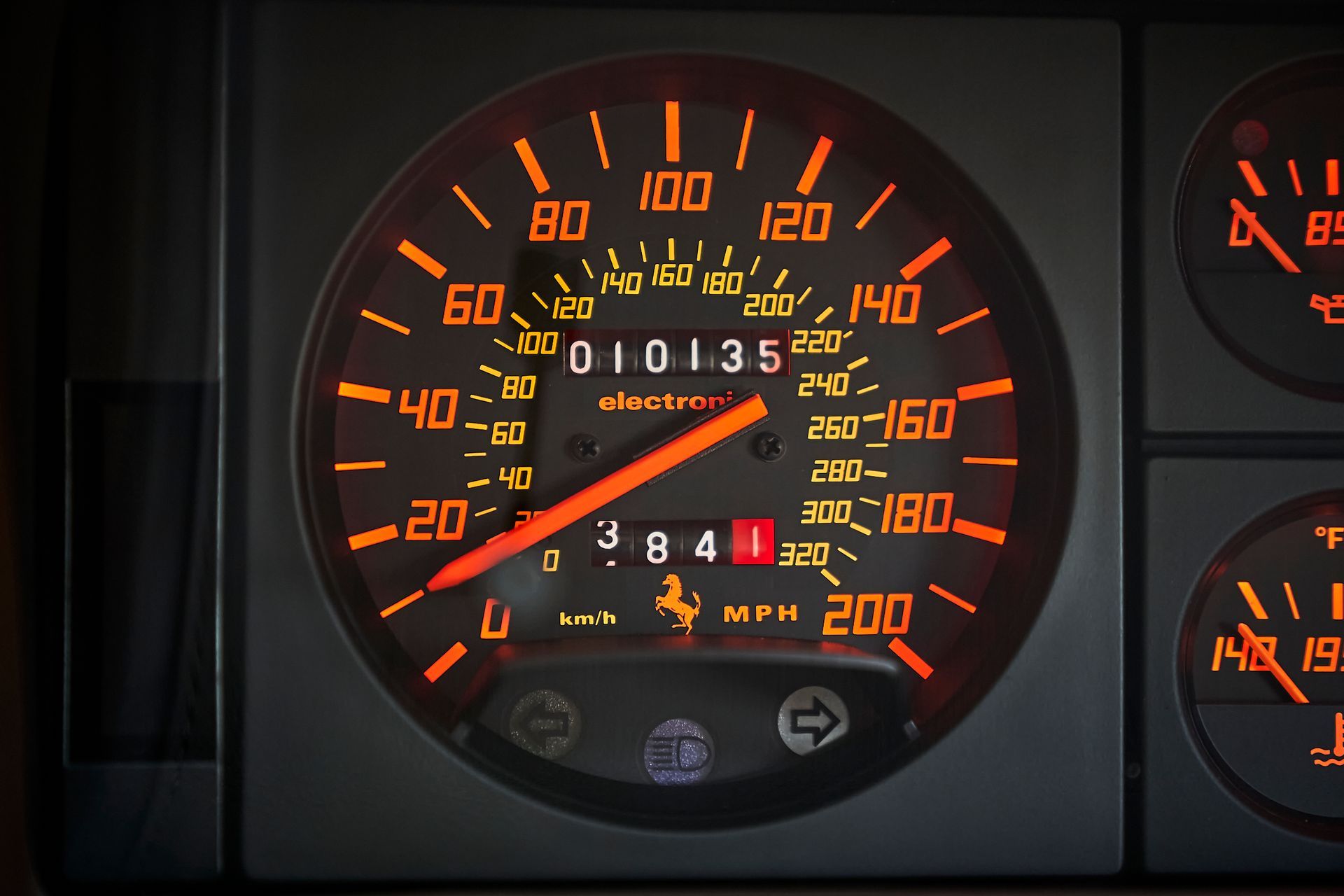 A close up of a speedometer that reads 200 mph