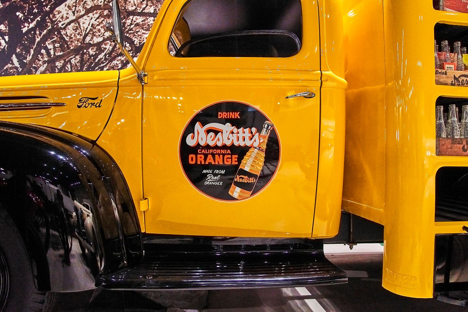 A yellow truck with a sticker on the door that says jack 's orange