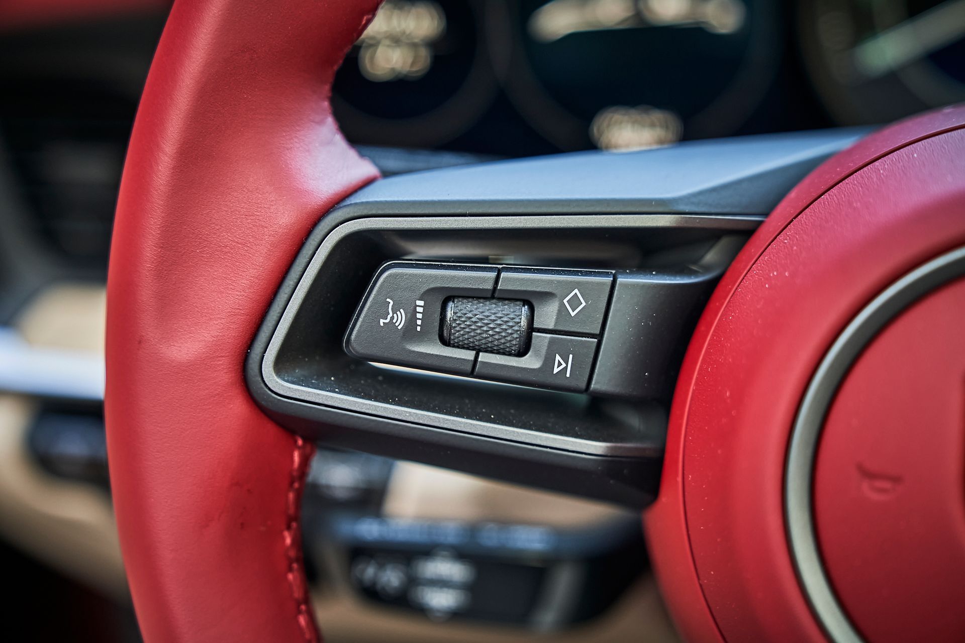 A close up of a car steering wheel with a red steering wheel.