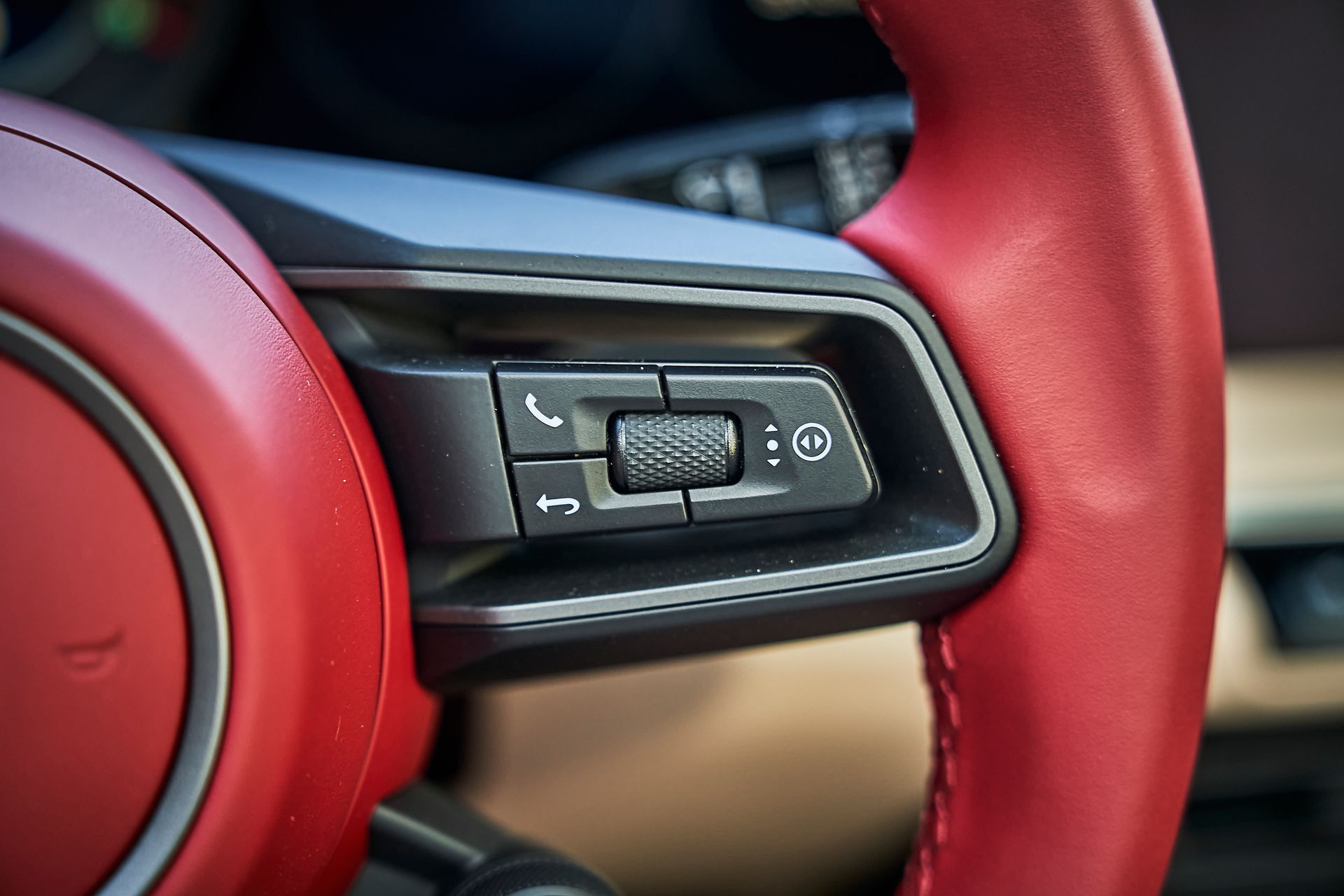 A close up of a red steering wheel in a car.