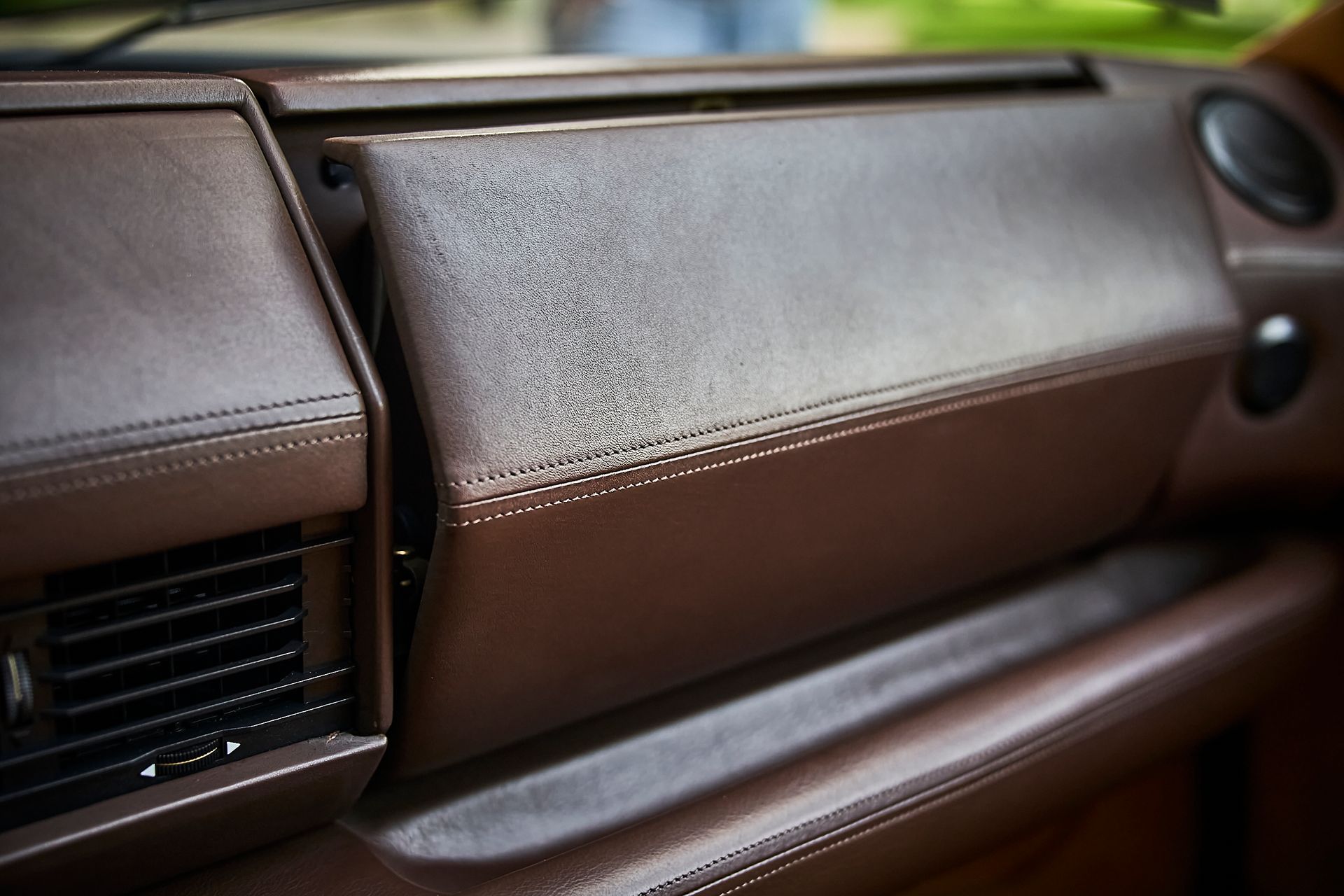 A close up of a brown leather dashboard in a car