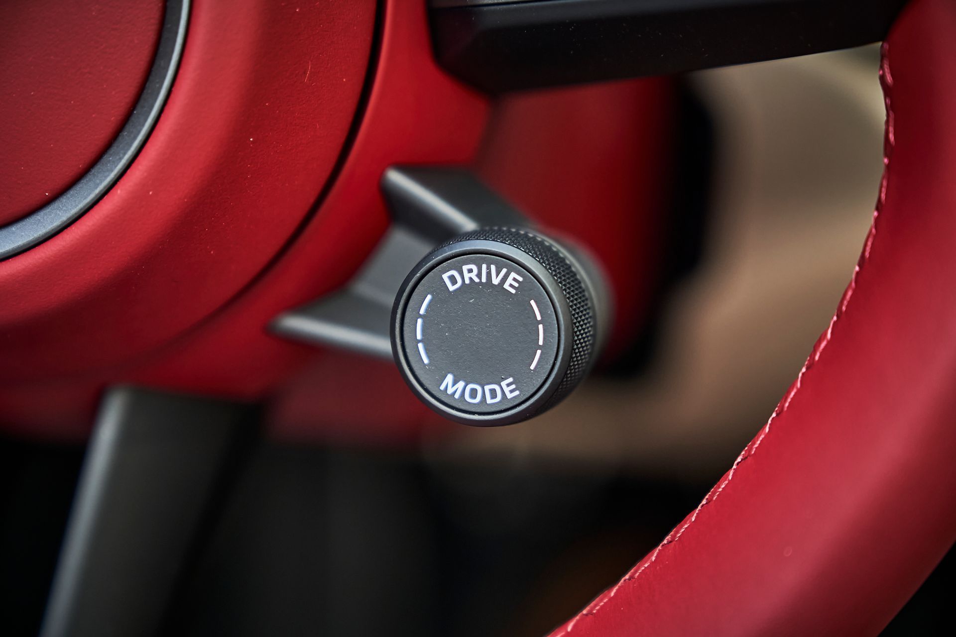 A close up of a steering wheel with a drive mode button on it.