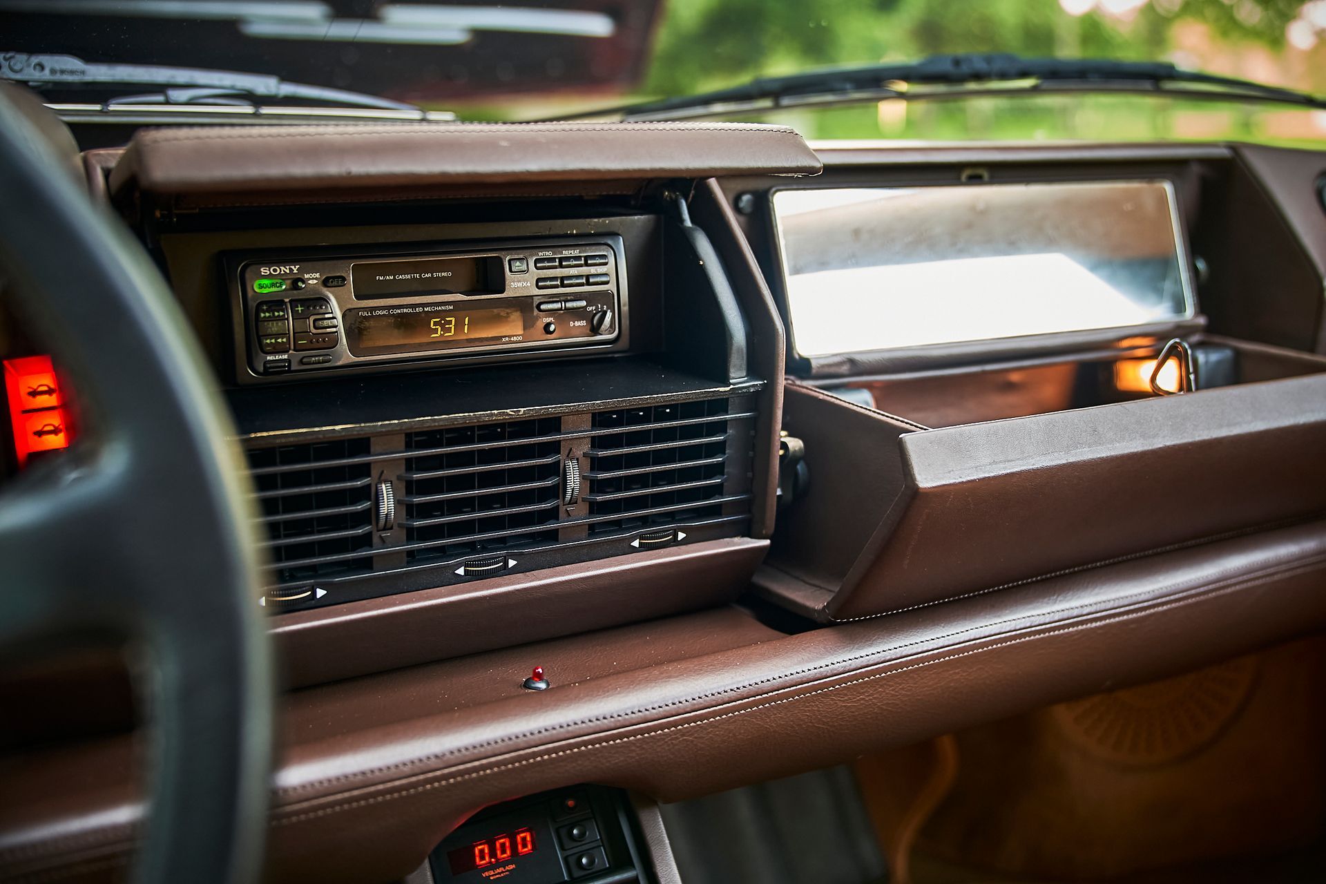 The dashboard of a car with a radio and a steering wheel.
