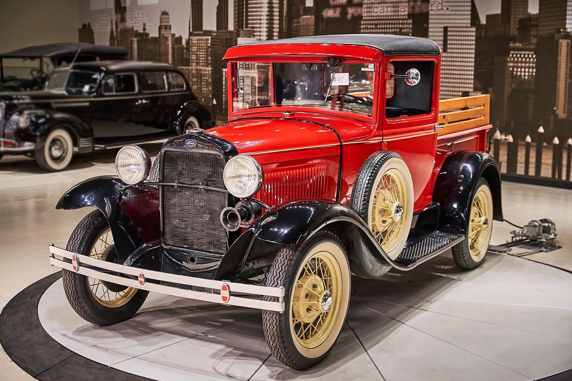 An old red truck with a wooden bed is parked in a garage.
