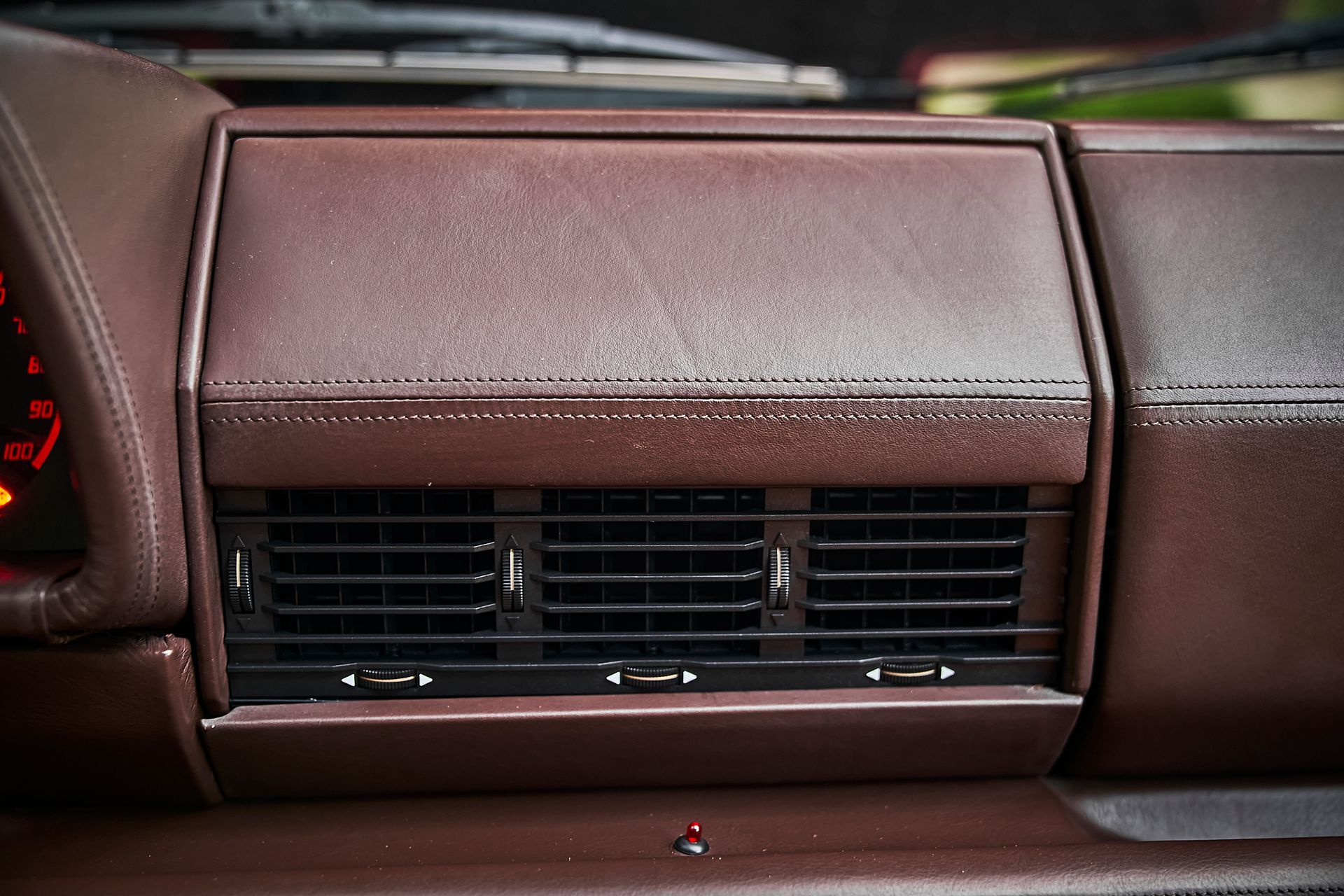 A close up of a brown leather dashboard in a car.