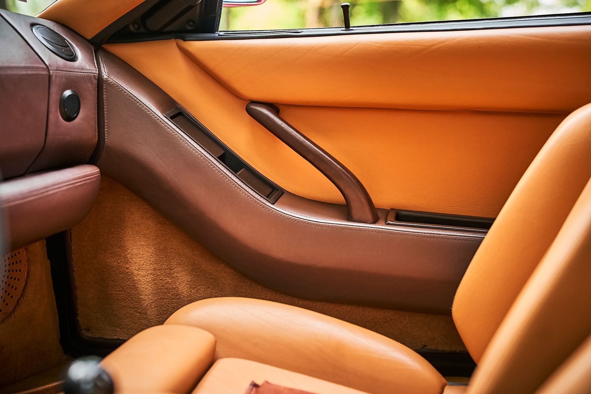 A close up of a car door with brown leather seats
