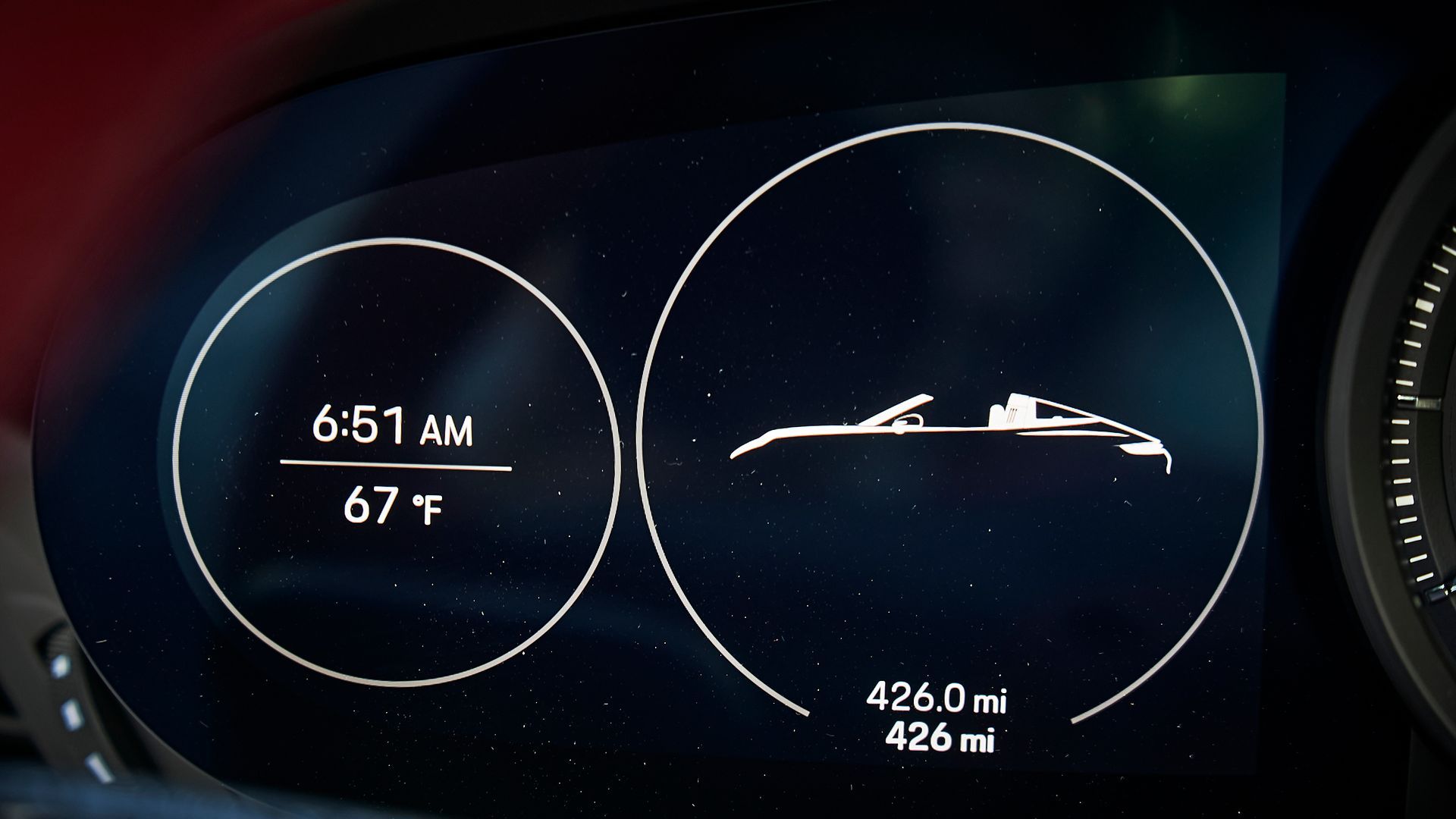 A car dashboard shows a time of 6:51 am and a temperature of 67 degrees