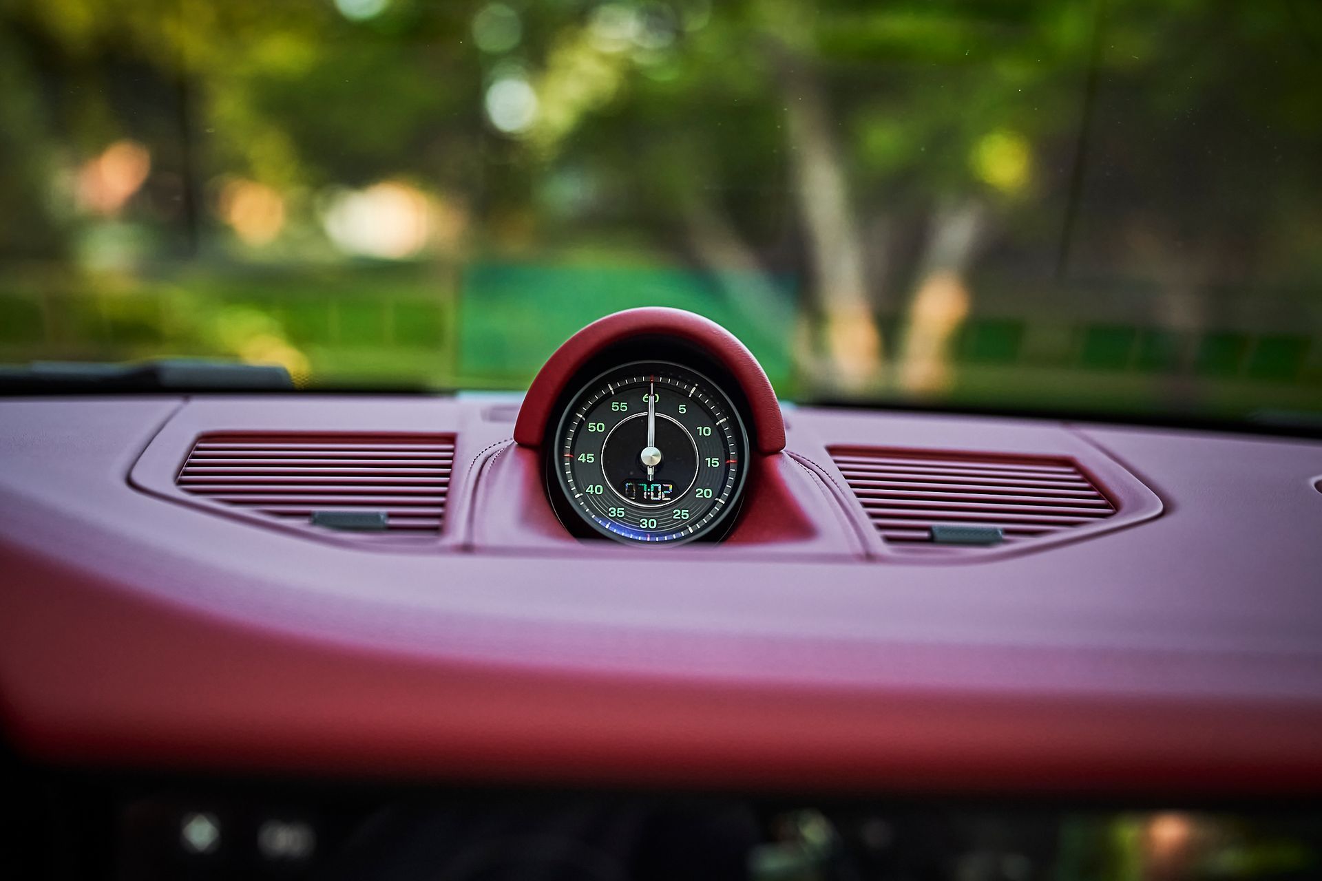 A close up of a clock on the dashboard of a car.