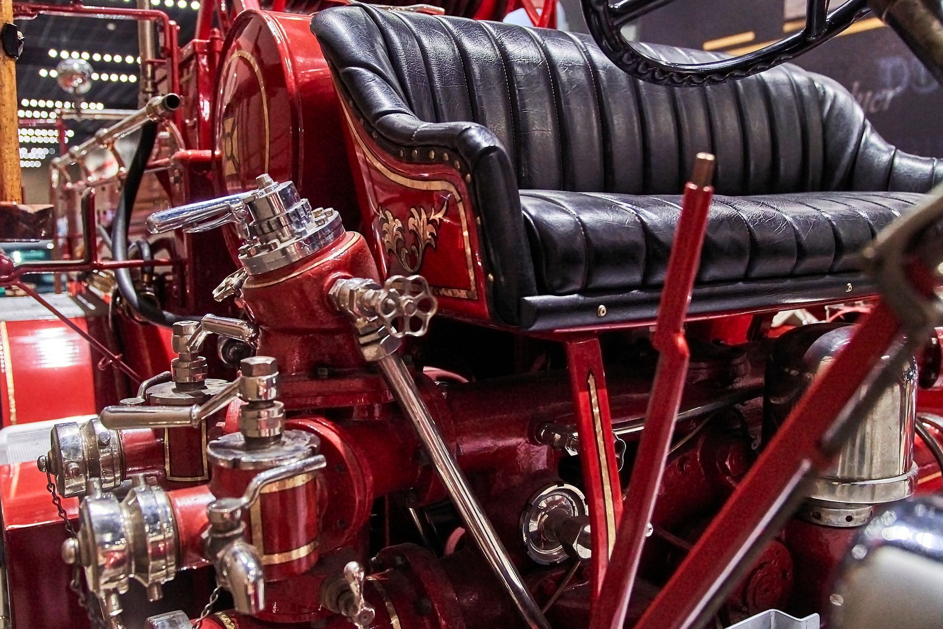 An old red fire truck with a black seat and steering wheel