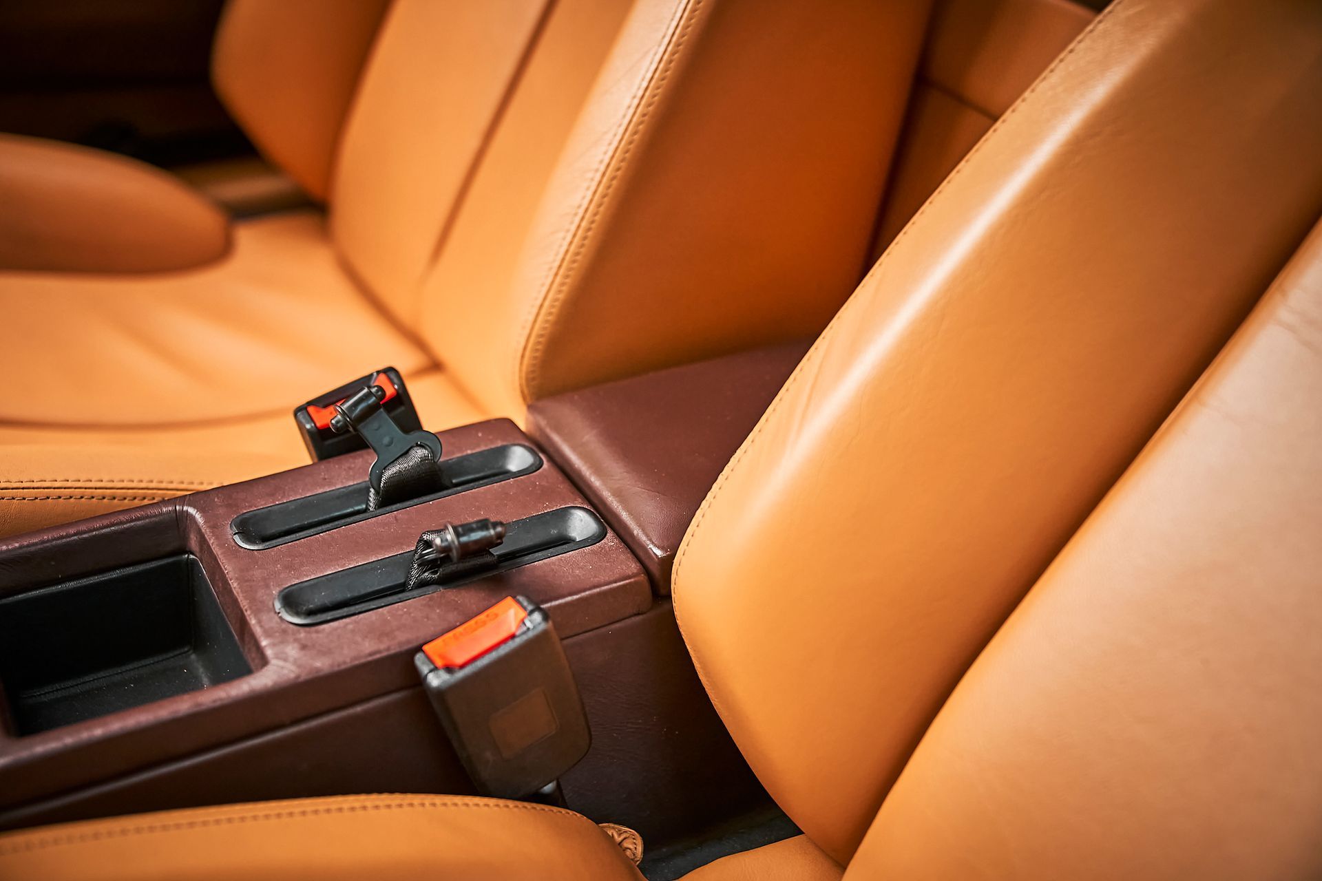 The interior of a car with brown leather seats and a center console.