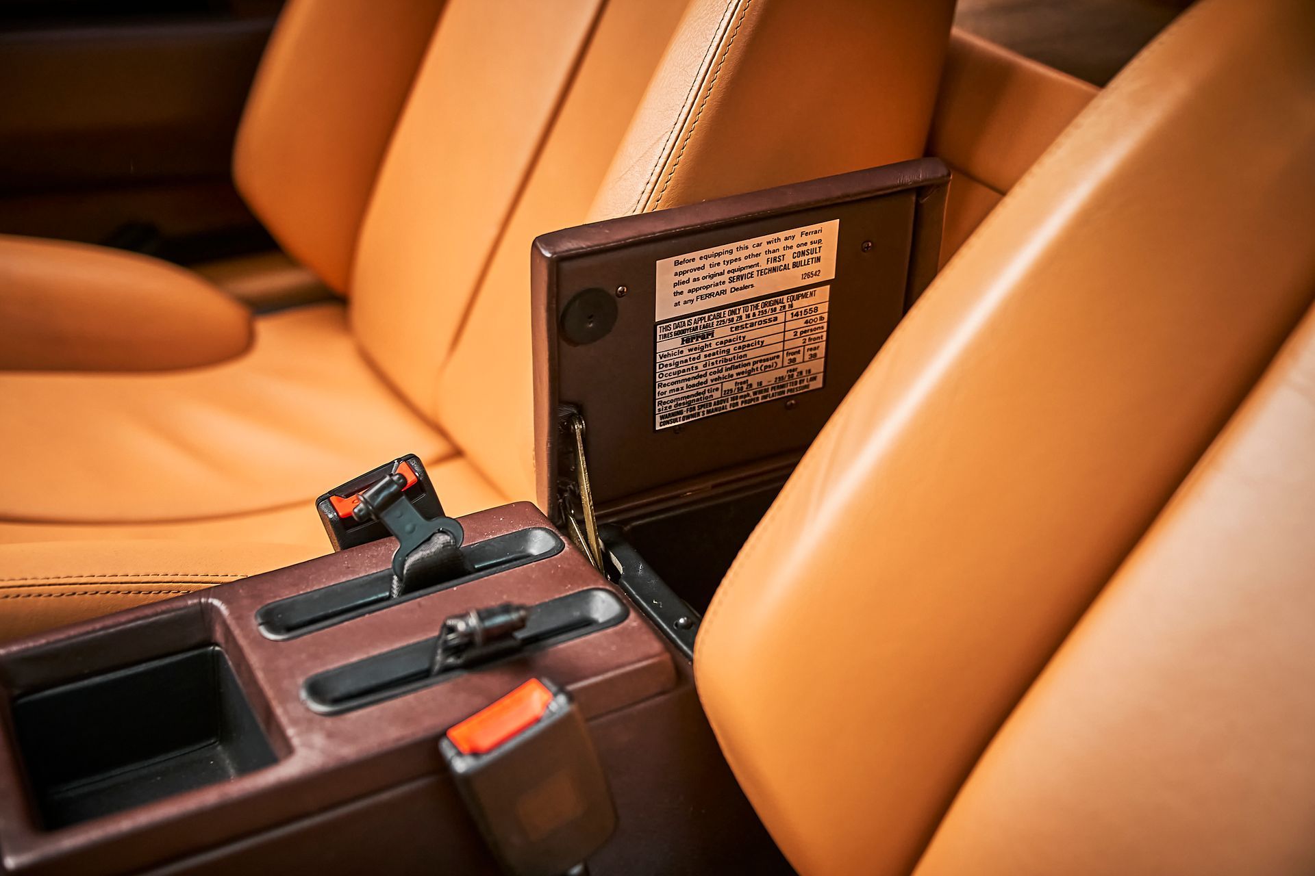 A close up of the interior of a car with brown leather seats and a center console.