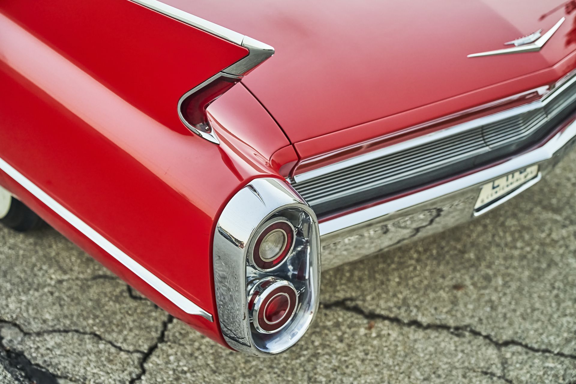 The rear end of a red cadillac is shown