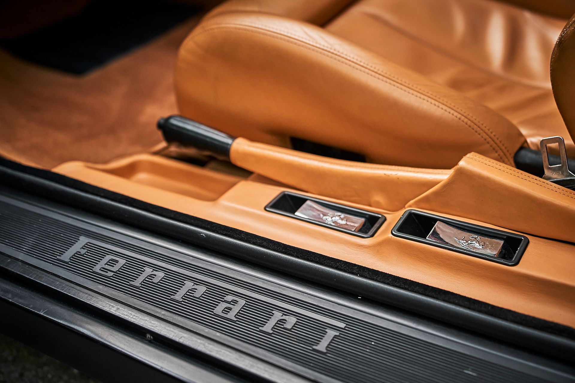 A close up of a car door with the word aston martin on it.