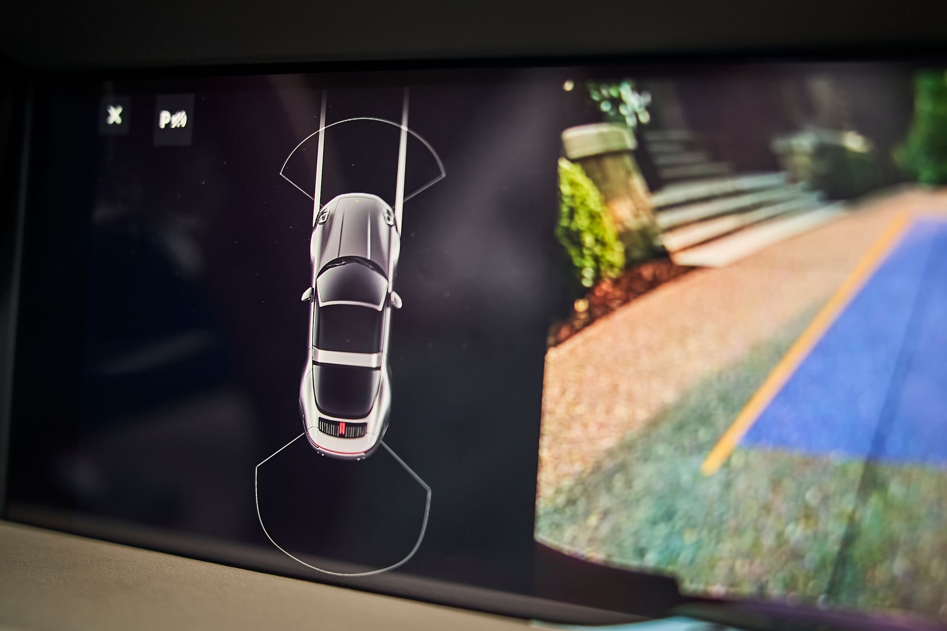 A rear view camera shows a car driving down a road.