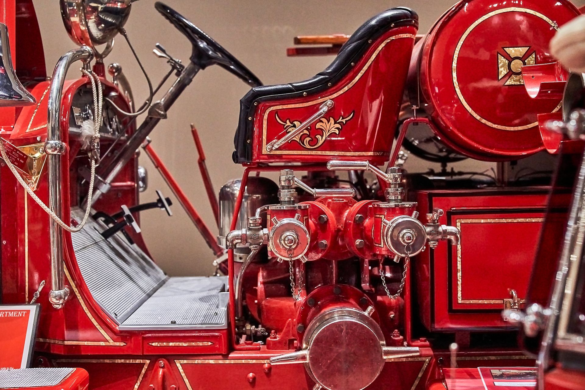 The inside of an old red fire truck with a steering wheel