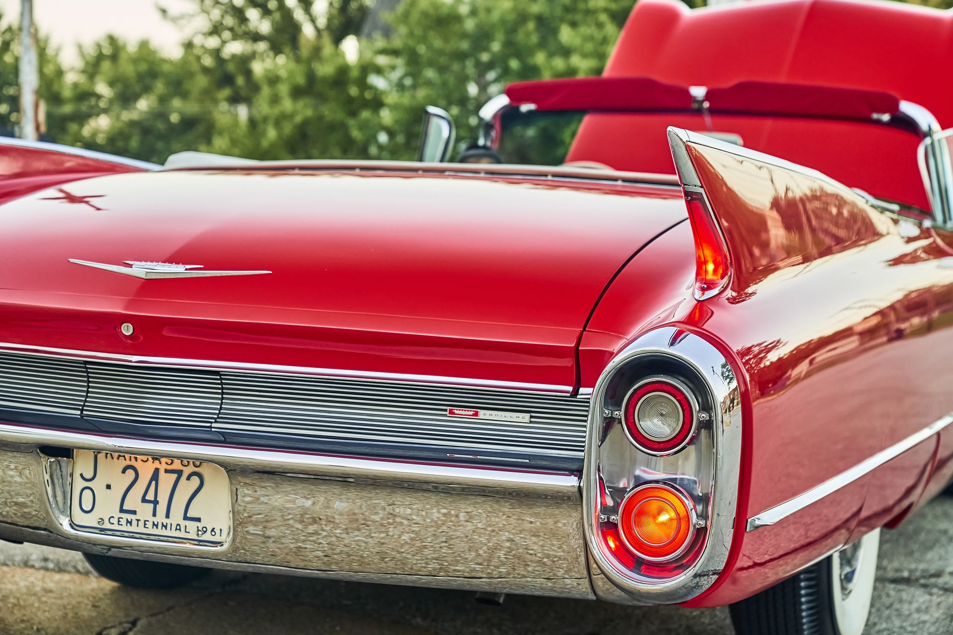 A red cadillac with a license plate that says j62472