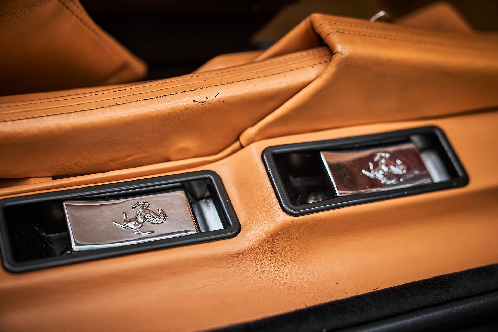 A close up of a car door with a ferrari logo on it.