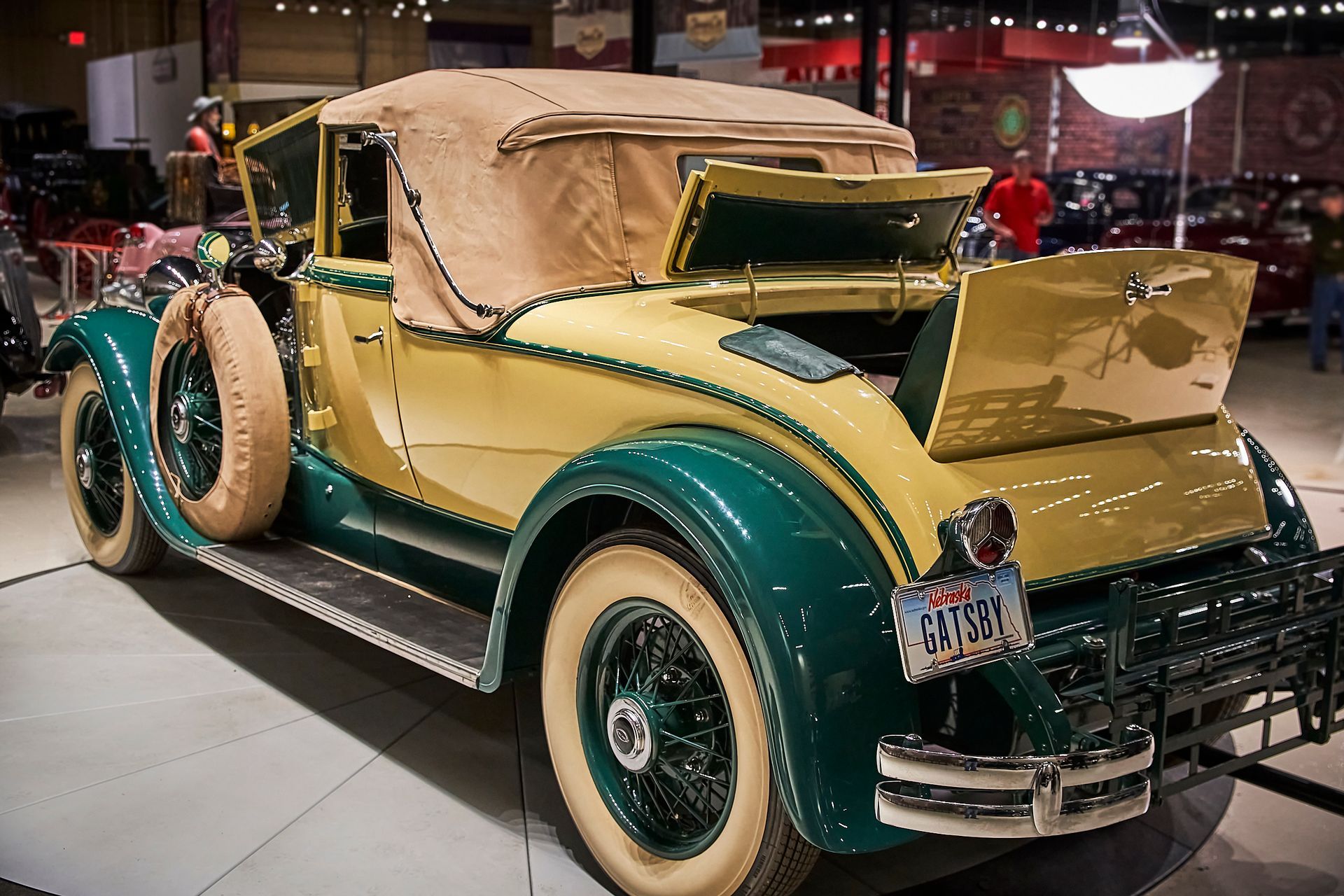 A green and tan vintage car with a license plate that says ' nc ' on it