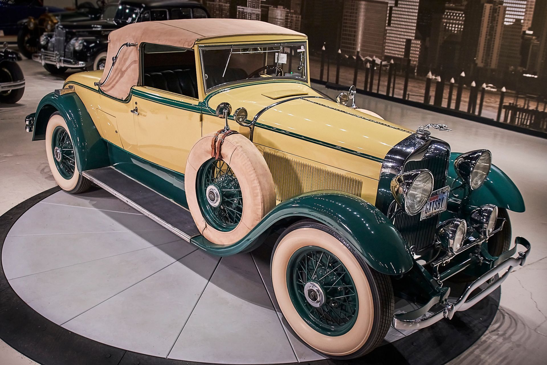 A yellow and green car with white tires is on display