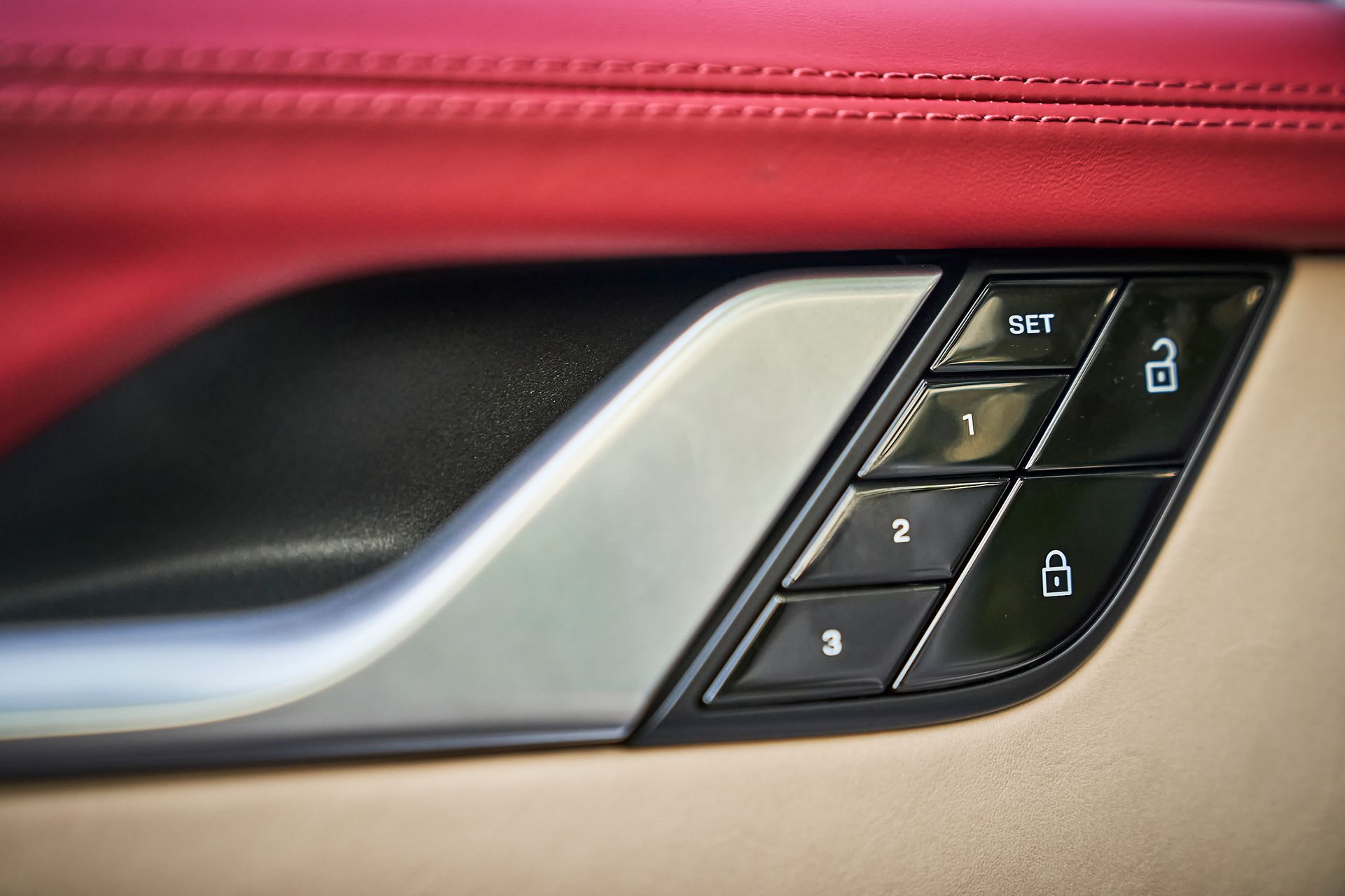 A close up of a car door handle with buttons on it.