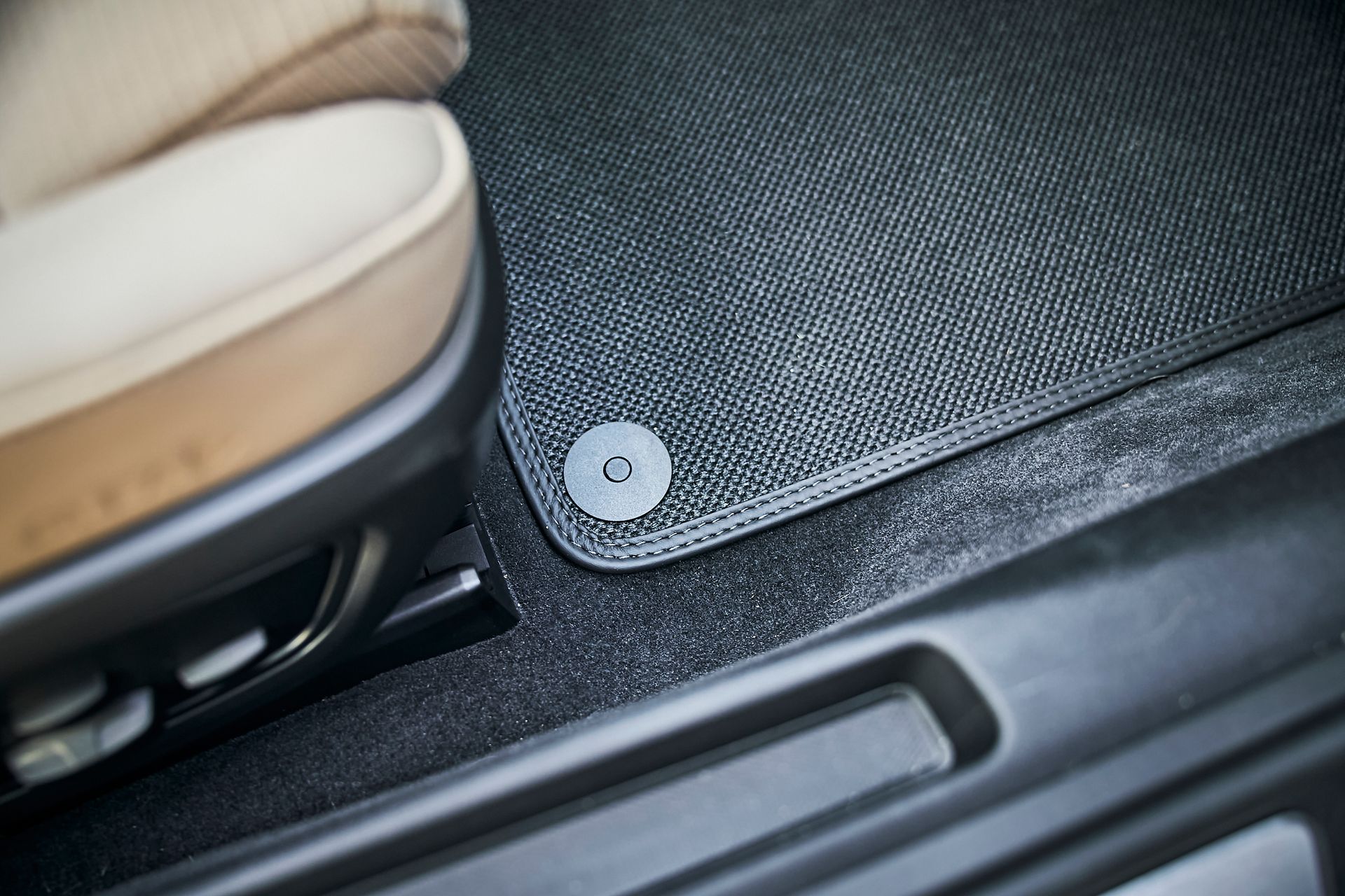 A close up of a car door mat next to a seat.