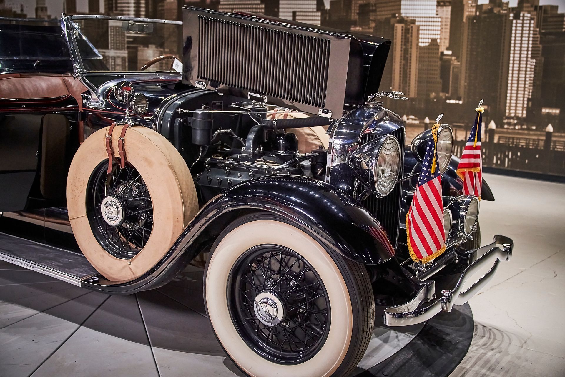 A black car with white tires and american flags on it