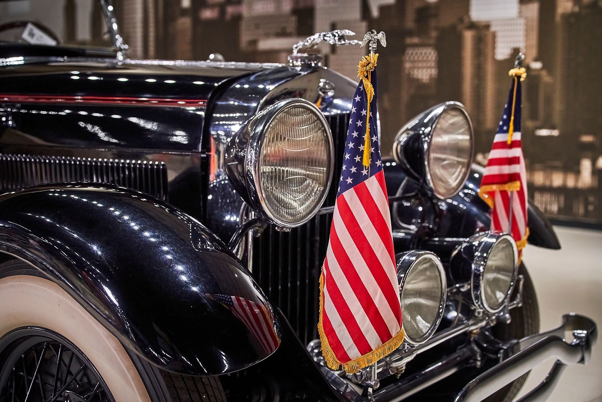 A black car with two american flags on the front
