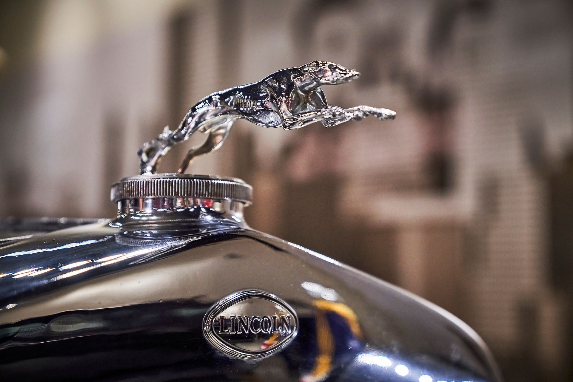 A close up of a car with a jaguar mascot on the hood.