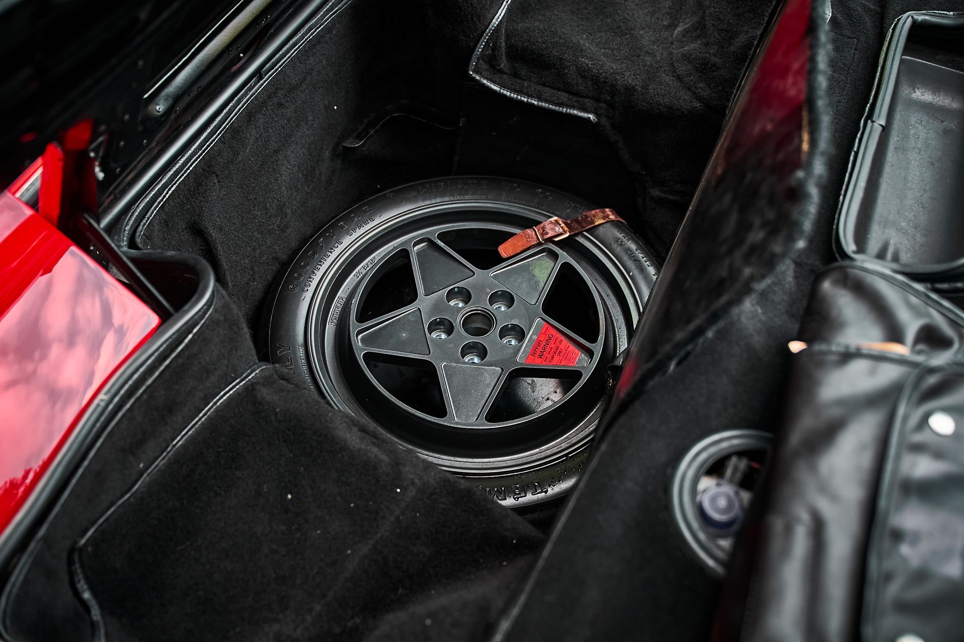 A close up of a spare tire in the trunk of a car.
