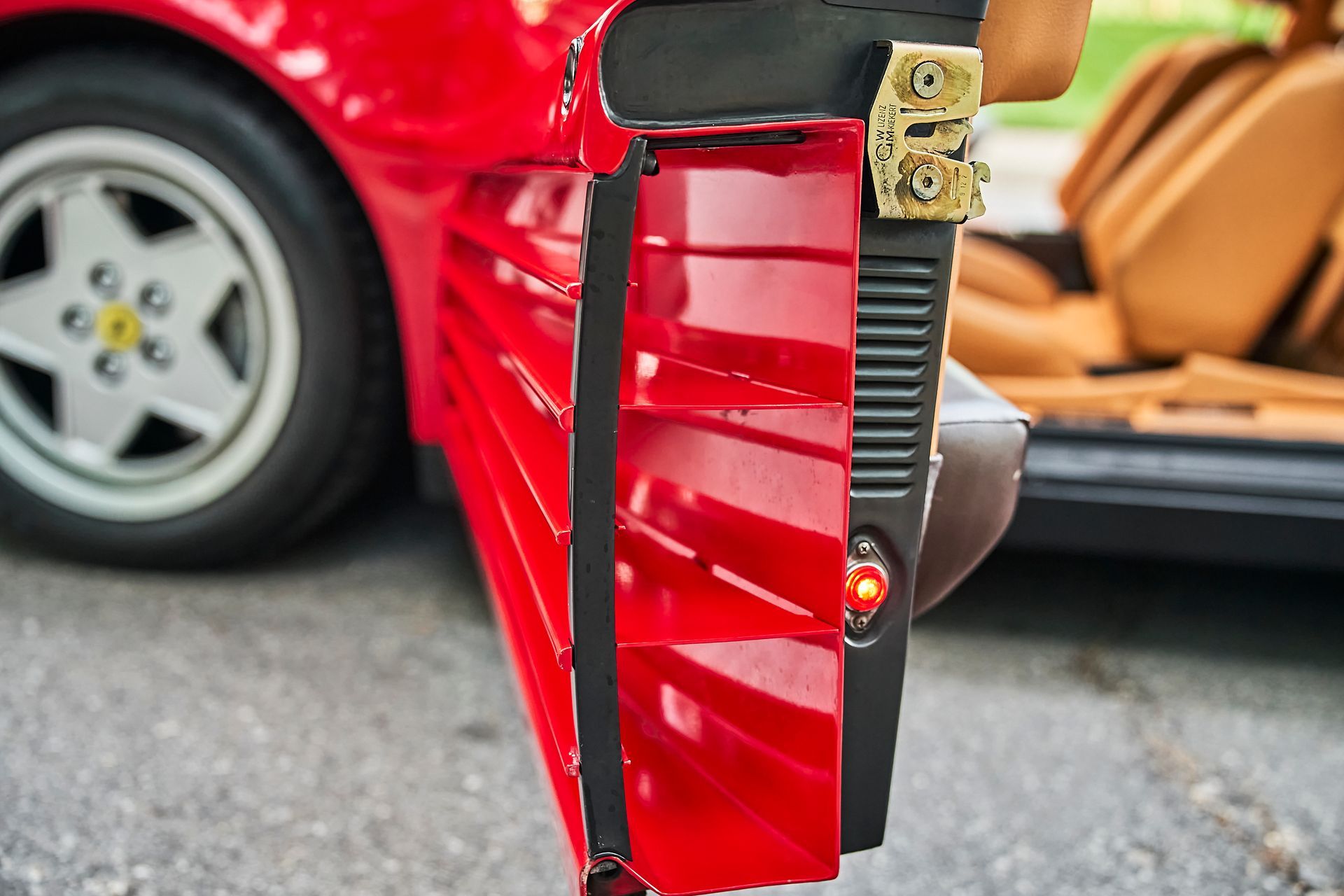 A red car is parked on the side of the road.
